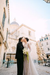 Vjenčani par na ulici grada Dubrovnika, romantično okruženje za vjenčane fotografije.