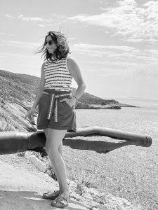 Crno-bijela portretna fotografija Ivane, Capturra fotograf koja pozira stojeći uz obalu mora tijekom fotografiranja za osobni branding.