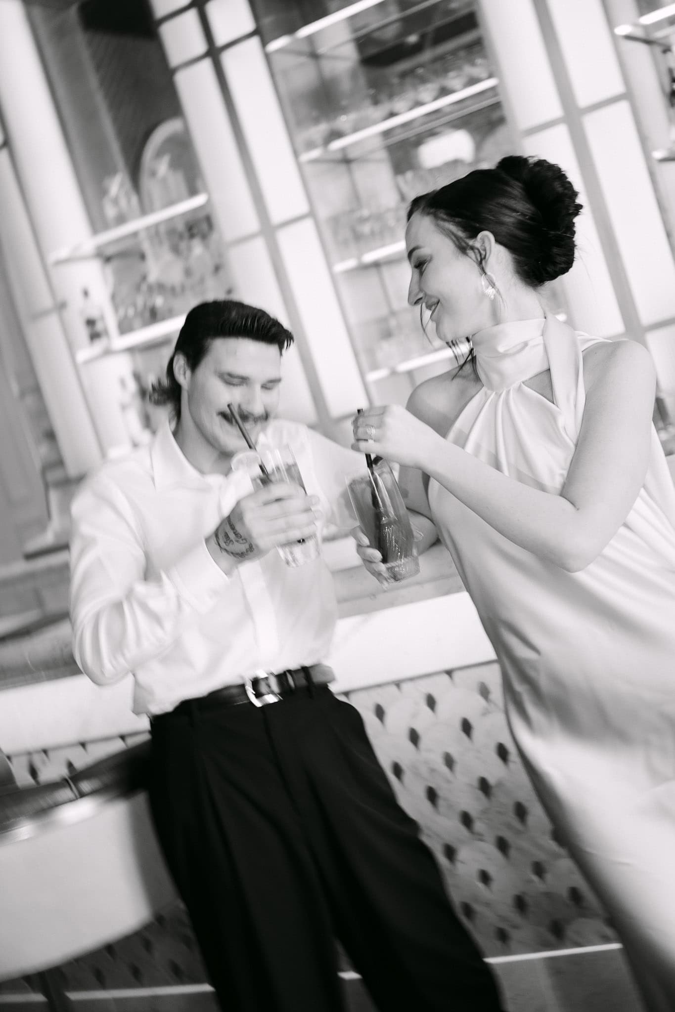 Dubrovnik wedding session - opušteni crno-bijeli kadar; nasmiješeni mladenci nazdravljaju koktelima za šankom bara.