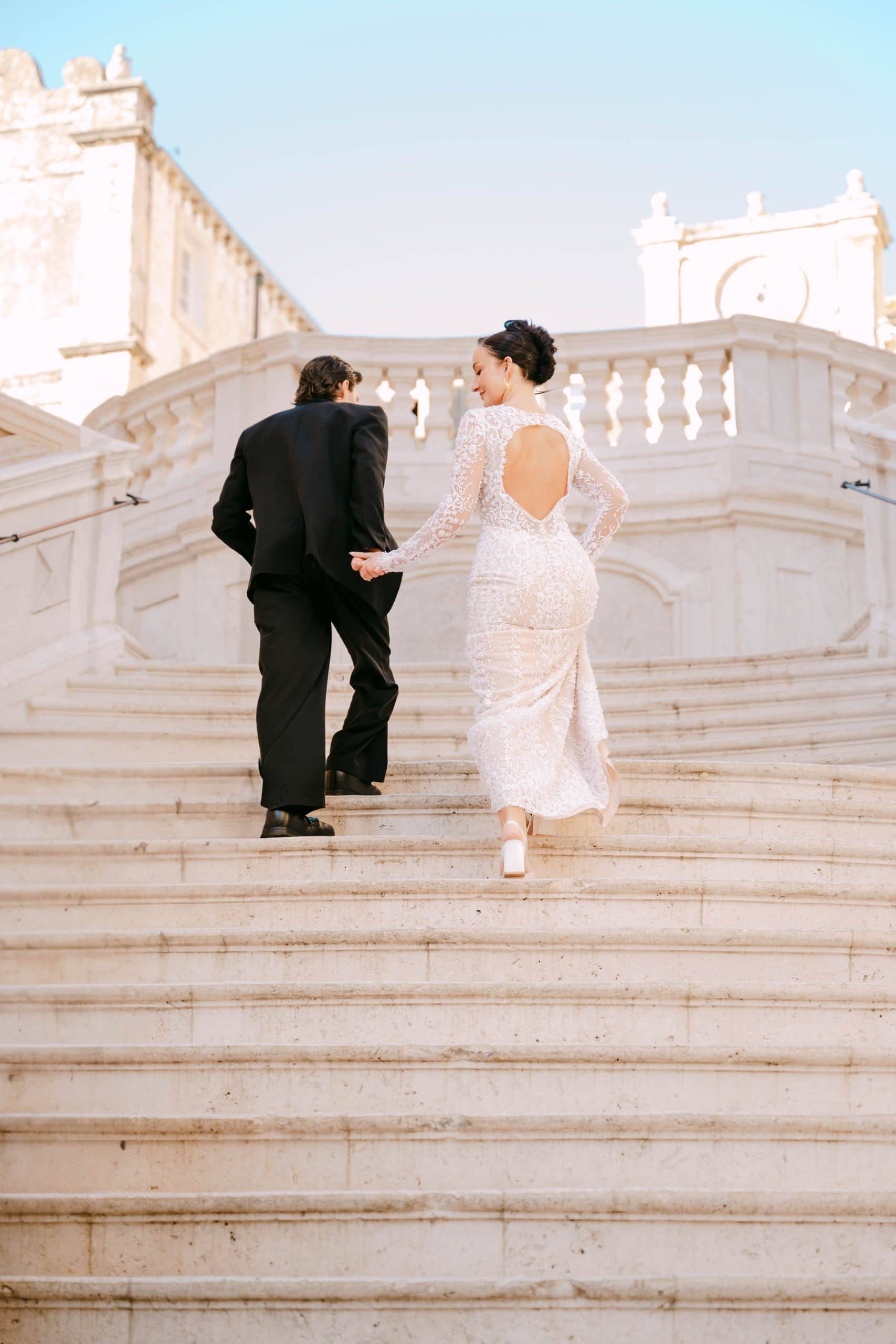 Vjenčani par hoda po stepenicama, romantična fotografija u starinskom okruženju.