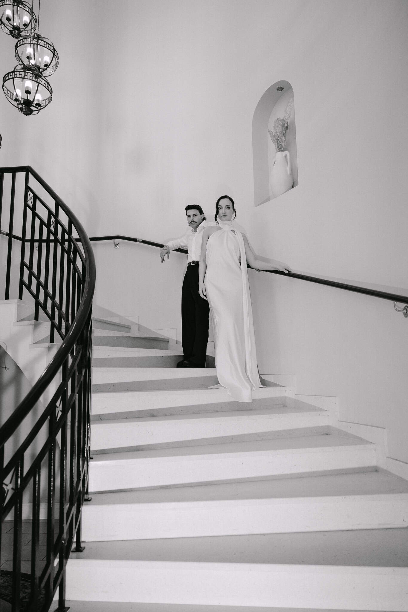 Vjenčanje Dubrovnik - široki crno-bijeli kadar; mladenci poziraju na elegantnom zavojitom stubištu unutar modernog hotela.