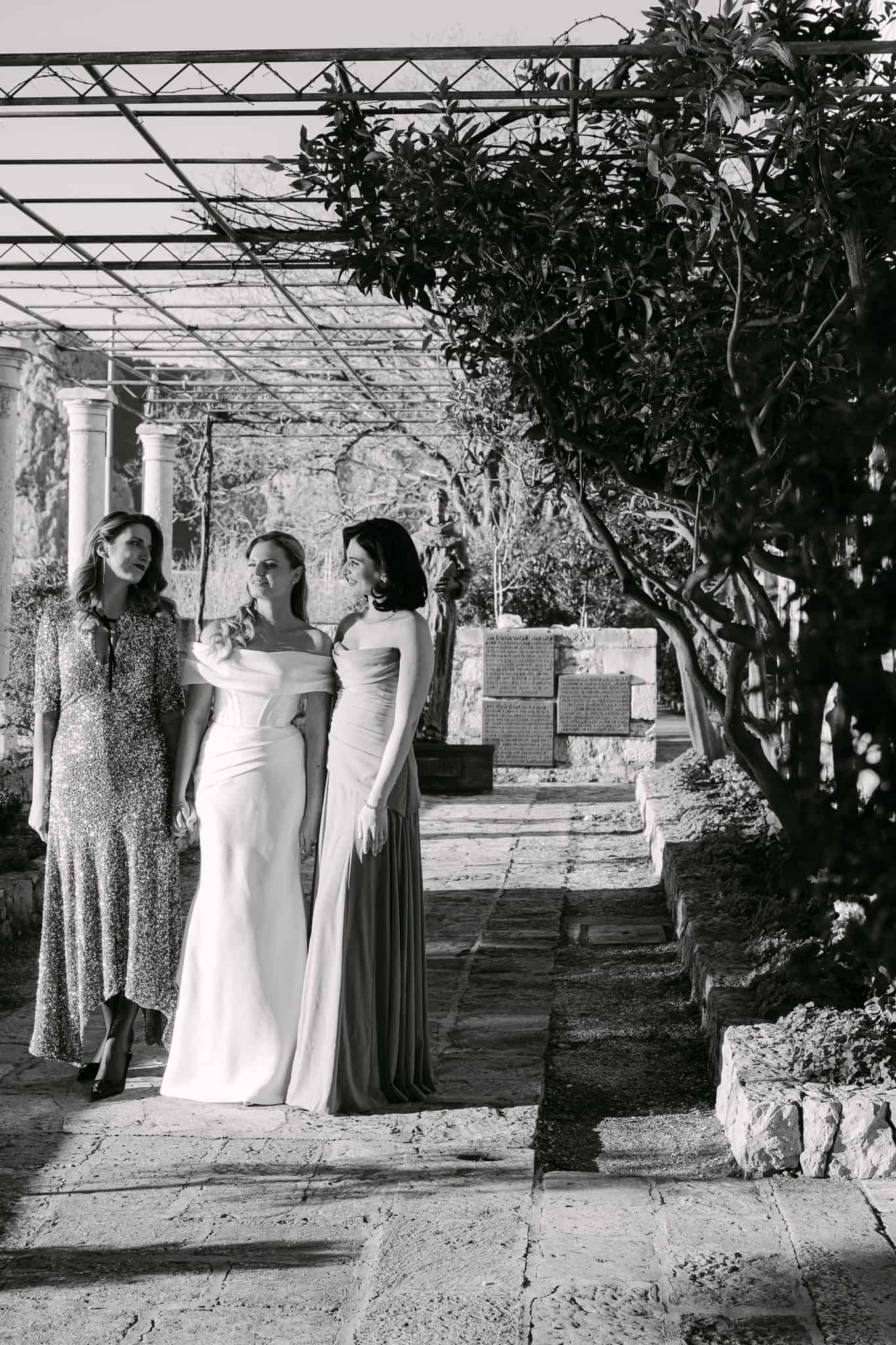 Mladenka i dvije djeveruše na kamenoj stazi na otvorenom tijekom vjenčanja u Omišu.