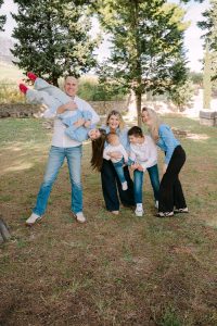 Obiteljska fotografija na otvorenom s osmijehom i igrom u prirodi.