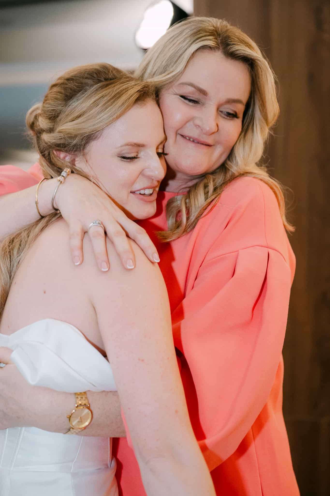 Iskreni emotivni trenutak koji spaja generacije; snažan i dubok zagrljaj prepun sreće i zatvorenih očiju između mladenke i njene majke tijekom proslave vjenčanja.