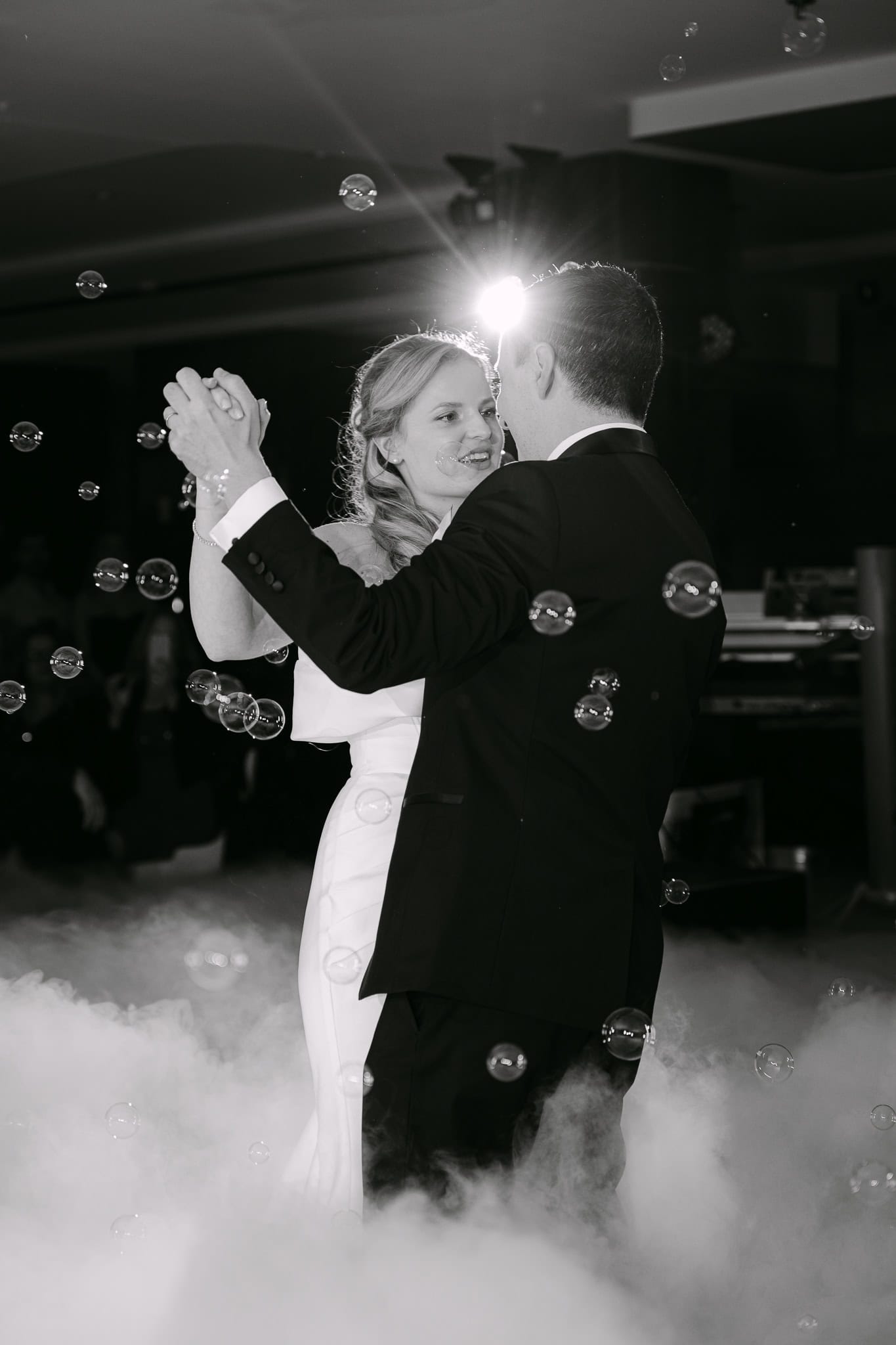 Vjenčani ples mladenaca na svadbenoj zabavi s dimom i balonima.