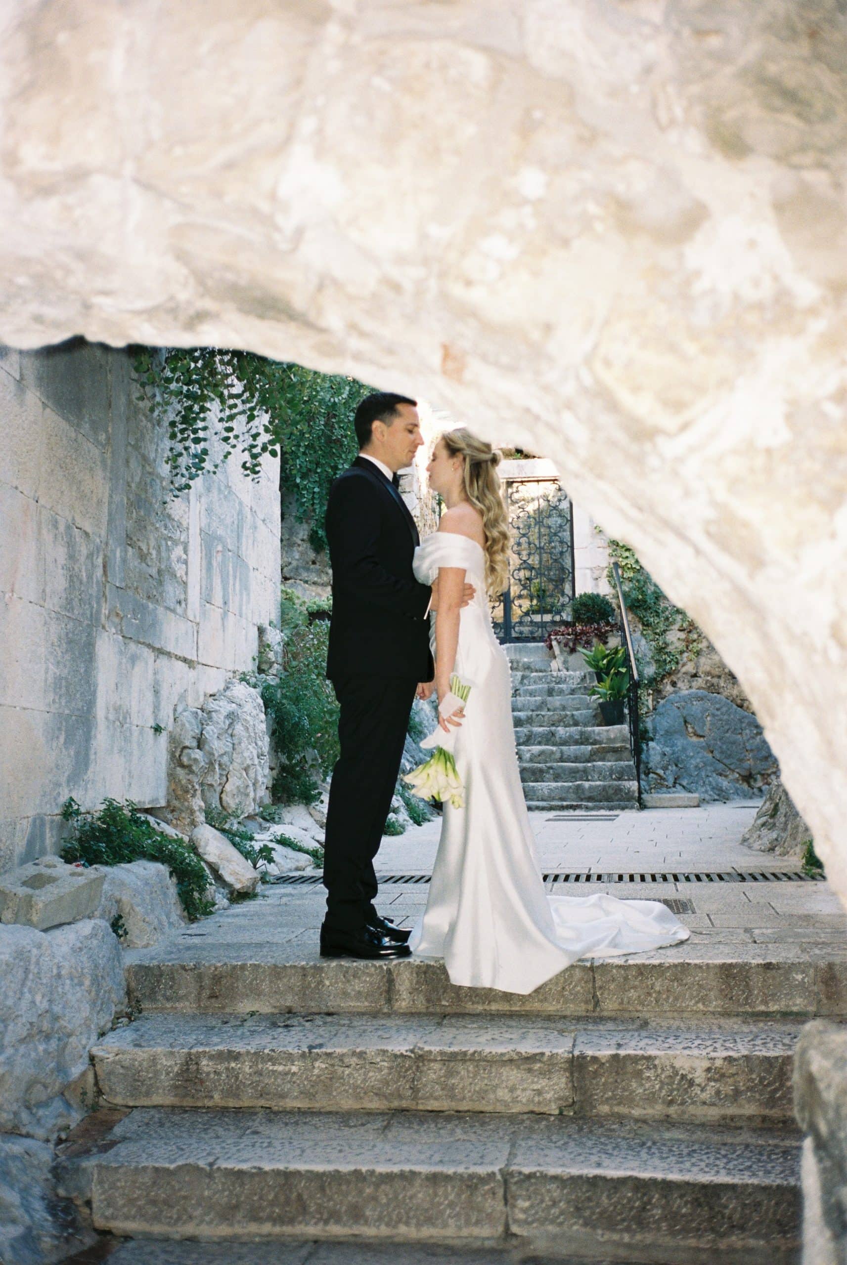 Vjenčani par na stepenicama, romantična fotografija u prirodnom okruženju.