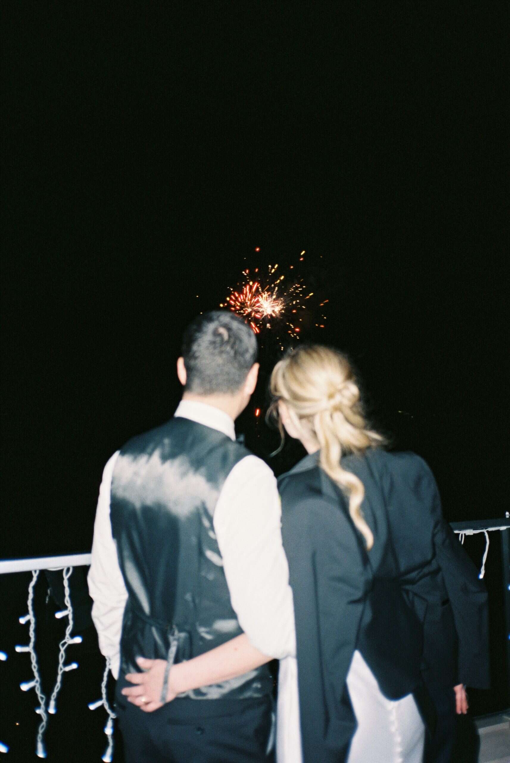 Vjenčani par gleda vatromet na otvorenom, romantična večer s spektakularnim prikazom na nebu.