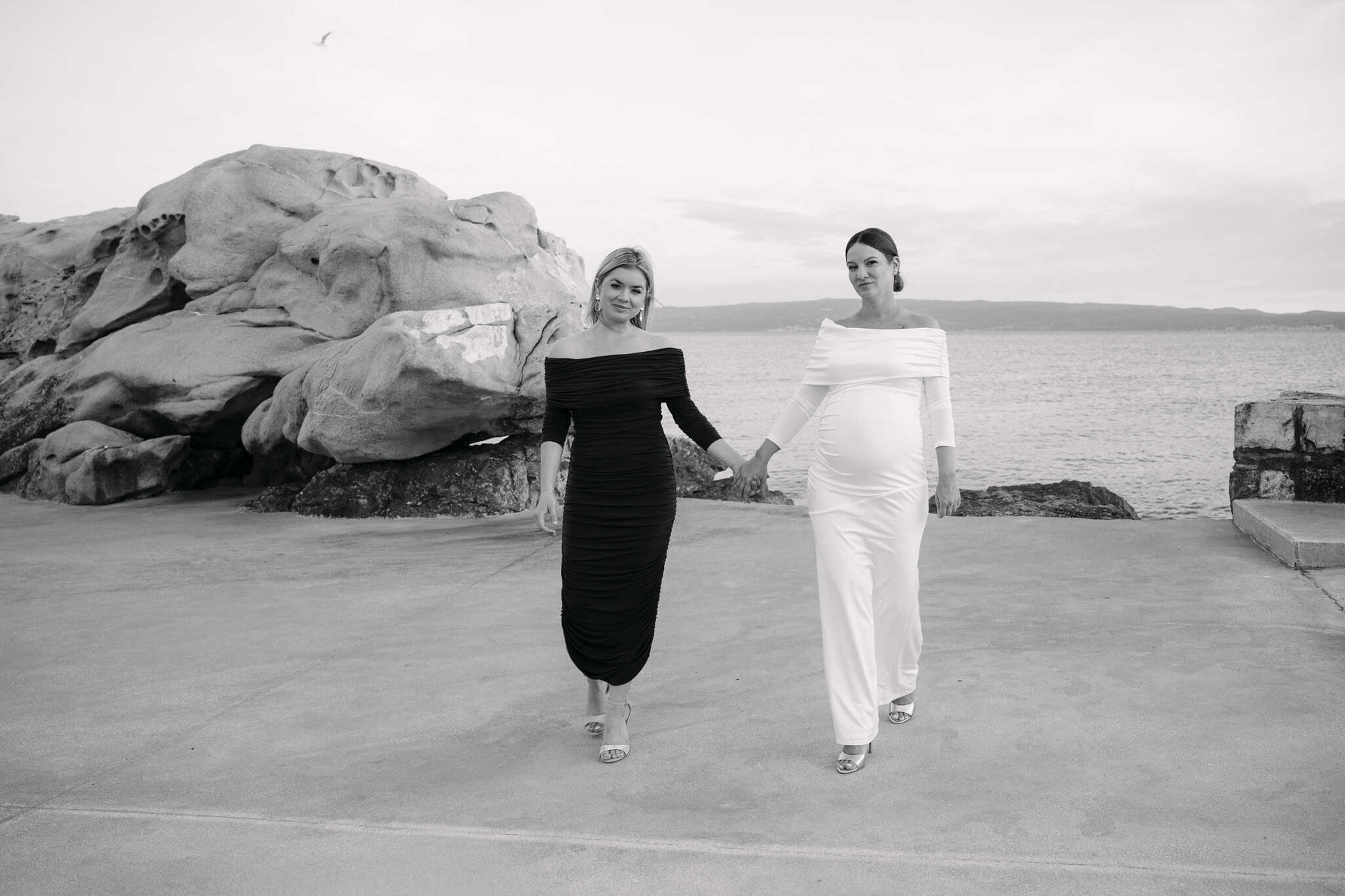 Kuma i mladenka hodaju ruku pod ruku uz obalnu šetnicu.