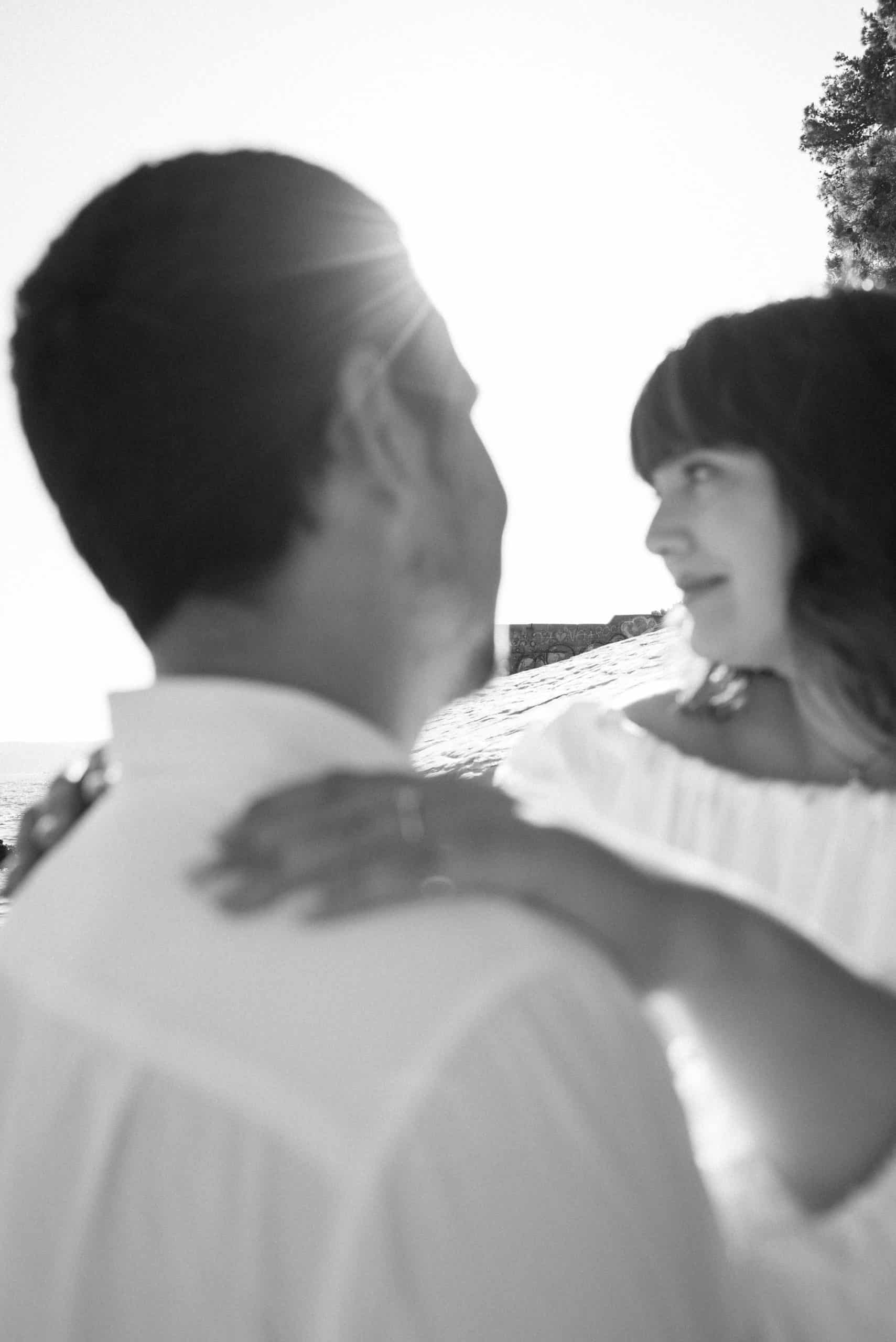 Zaručeni par par na plaži, snimljeno u crno-bijeloj tehnici, sunce i prirode u pozadini.