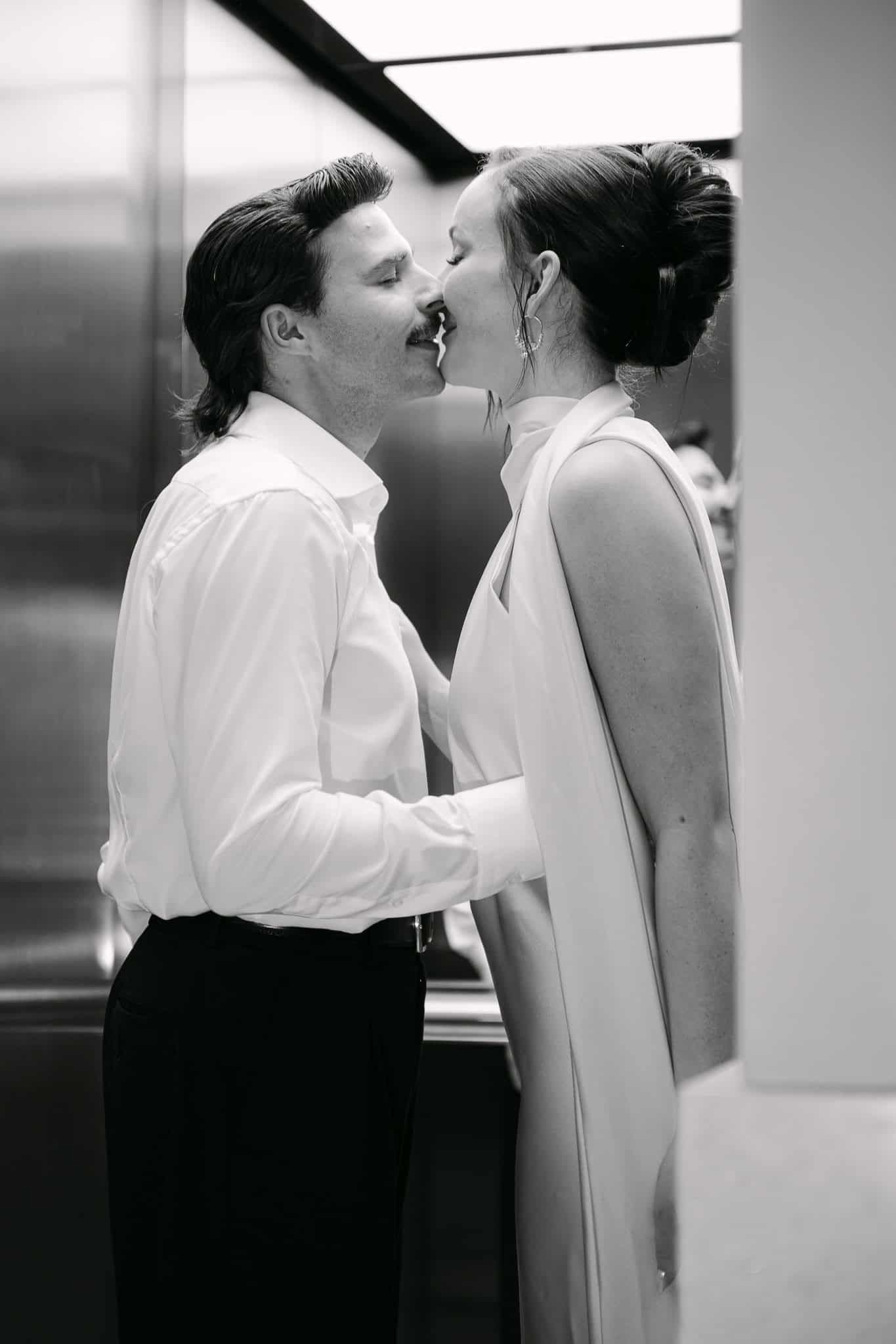 Vjenčani fotograf Dubrovnik - intimni crno-bijeli trenutak; mladoženja i mladenka tik do poljupca unutar modernog dizala.