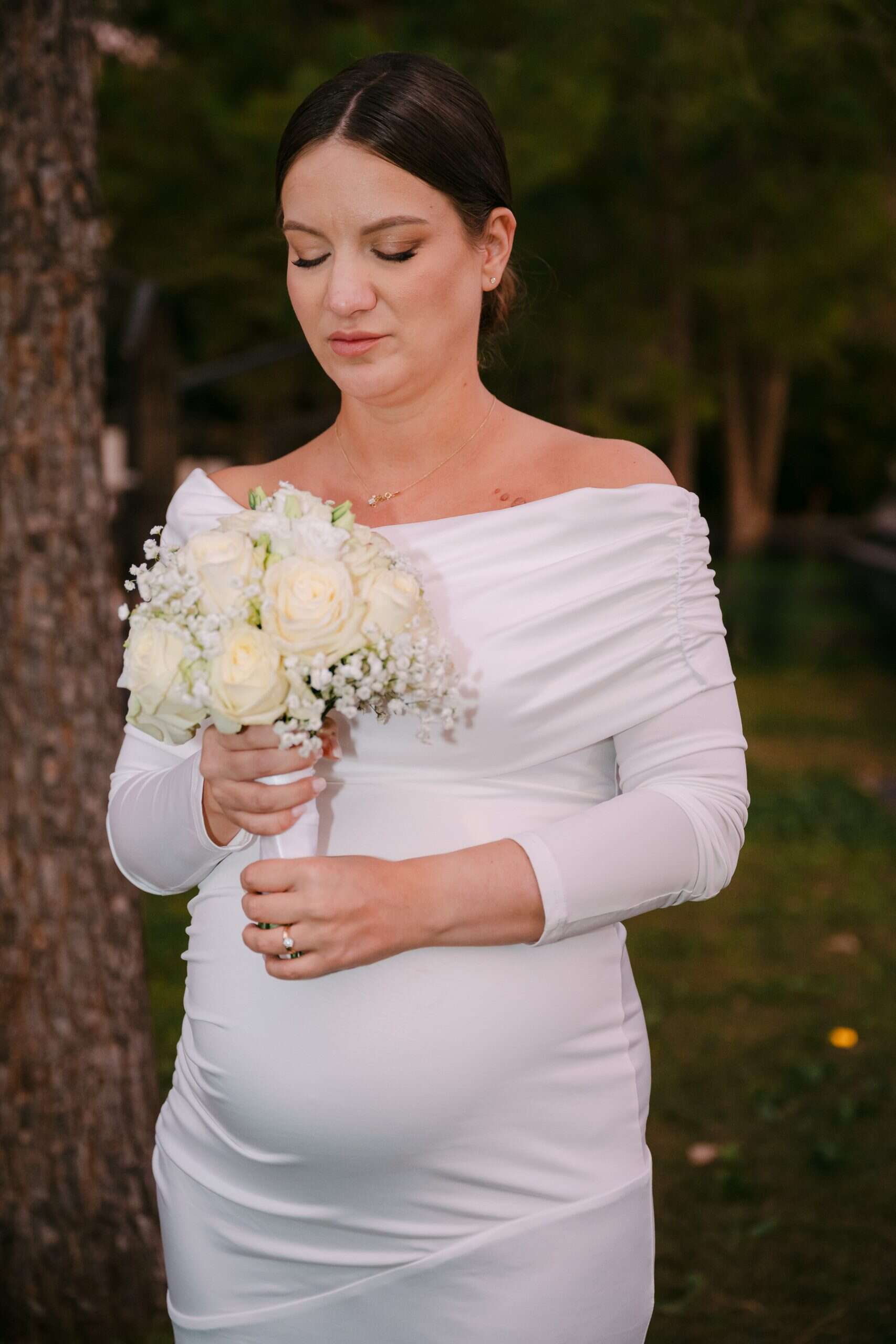Vjenčana fotografija mlade s buketom u prirodnom okruženju.