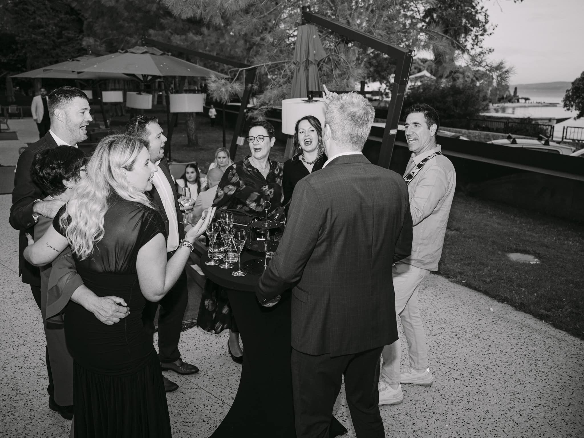 Ljudi uživaju u piću i pjesmi na vjenčanoj zabavi na otvorenom.