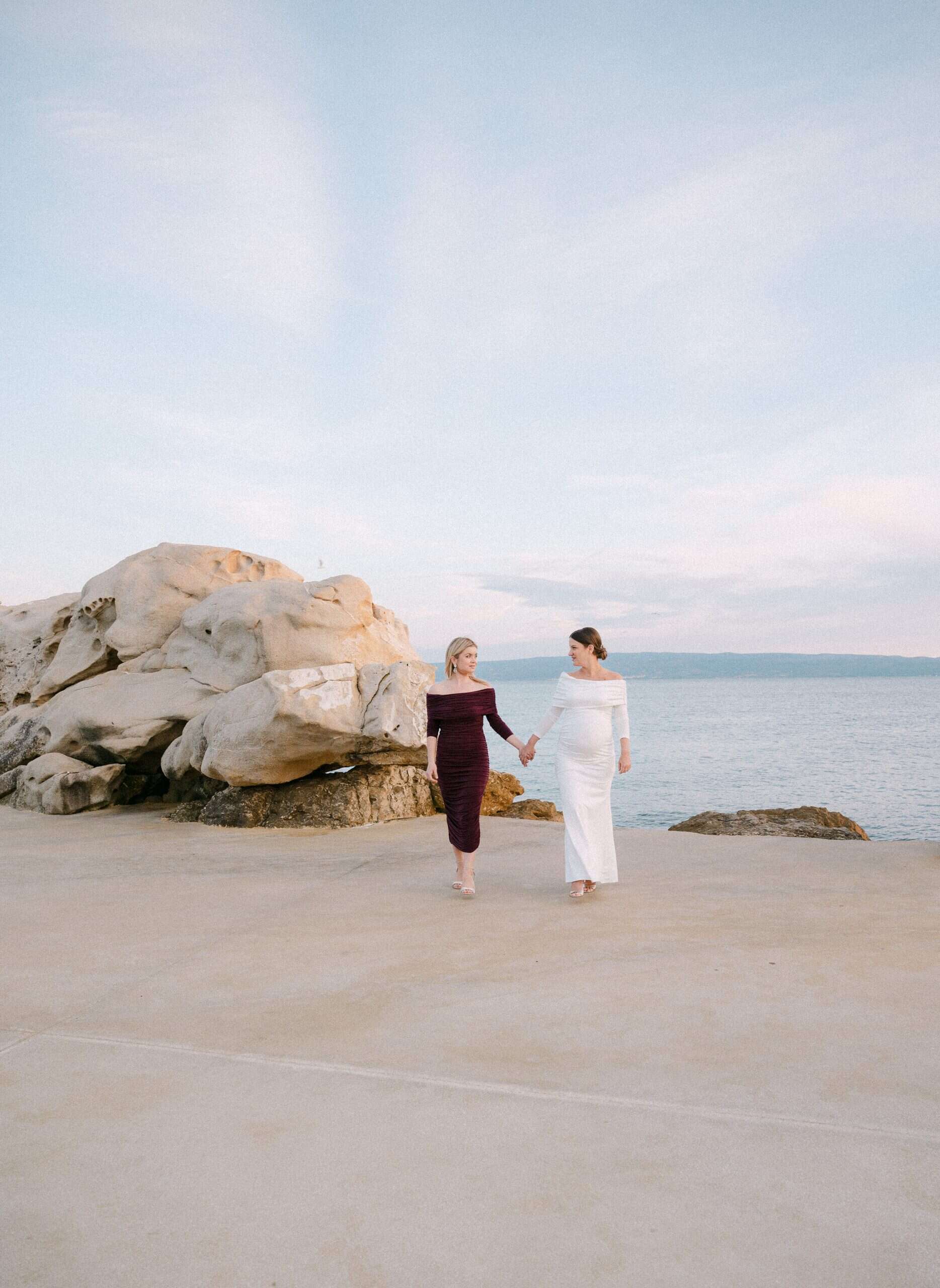 Mladenka Antonija i kuma drže se za ruke i gledaju jedna u drugu na plaži Bačvice u Splitu tijekom zalaska sunca.