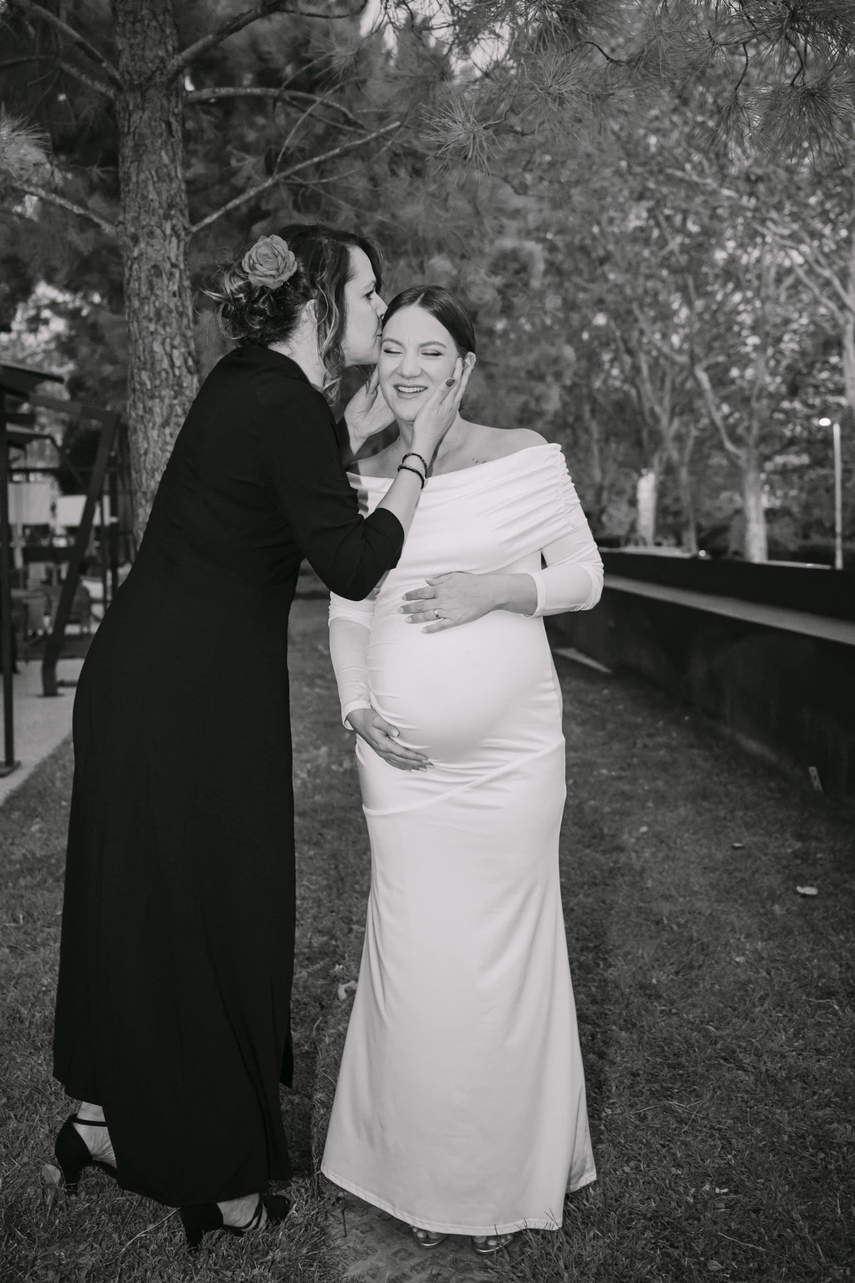 Emotivan trenutak mladenke i prijateljice na otvorenom.