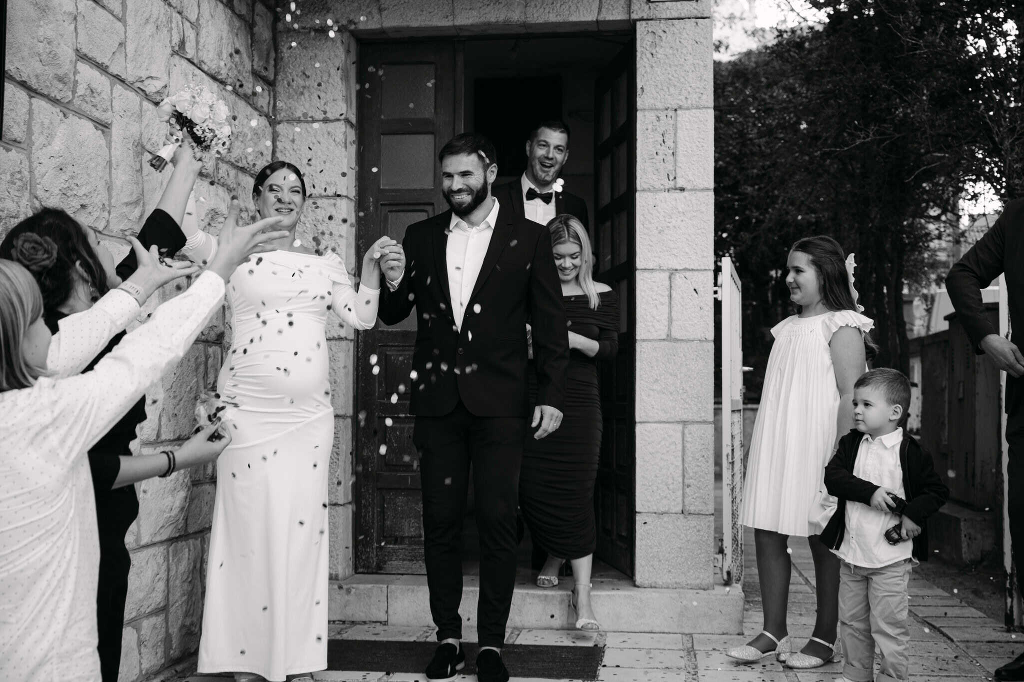 Vjenčani par s gostima, slavlje i radost na vjenčanju.