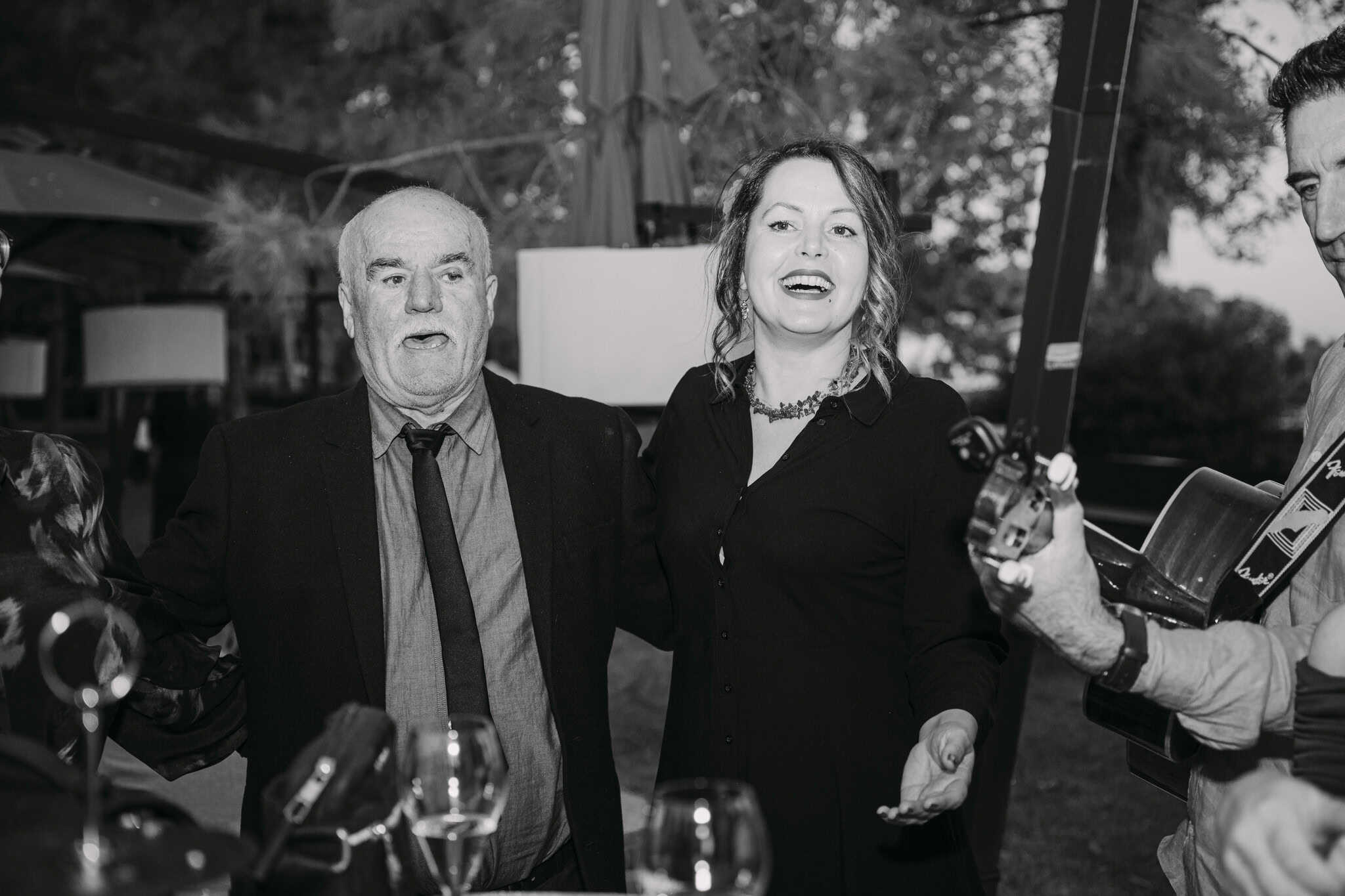 Elegantno druženje na otvorenom s ljudima koji uživaju u živoj glazbi na vjenčanju.