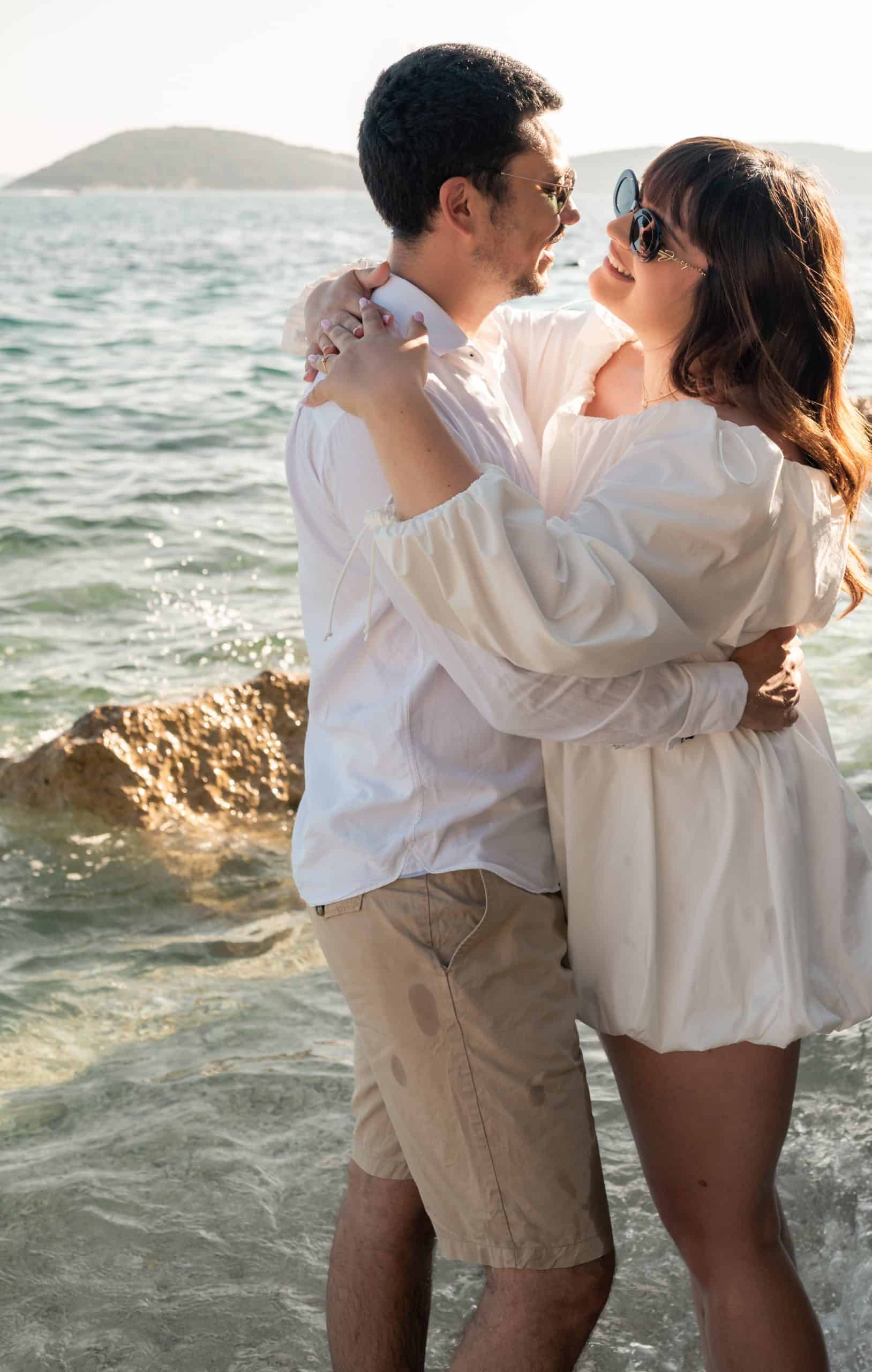 Ljubavni par na plaži, uživajući u suncu i moru.