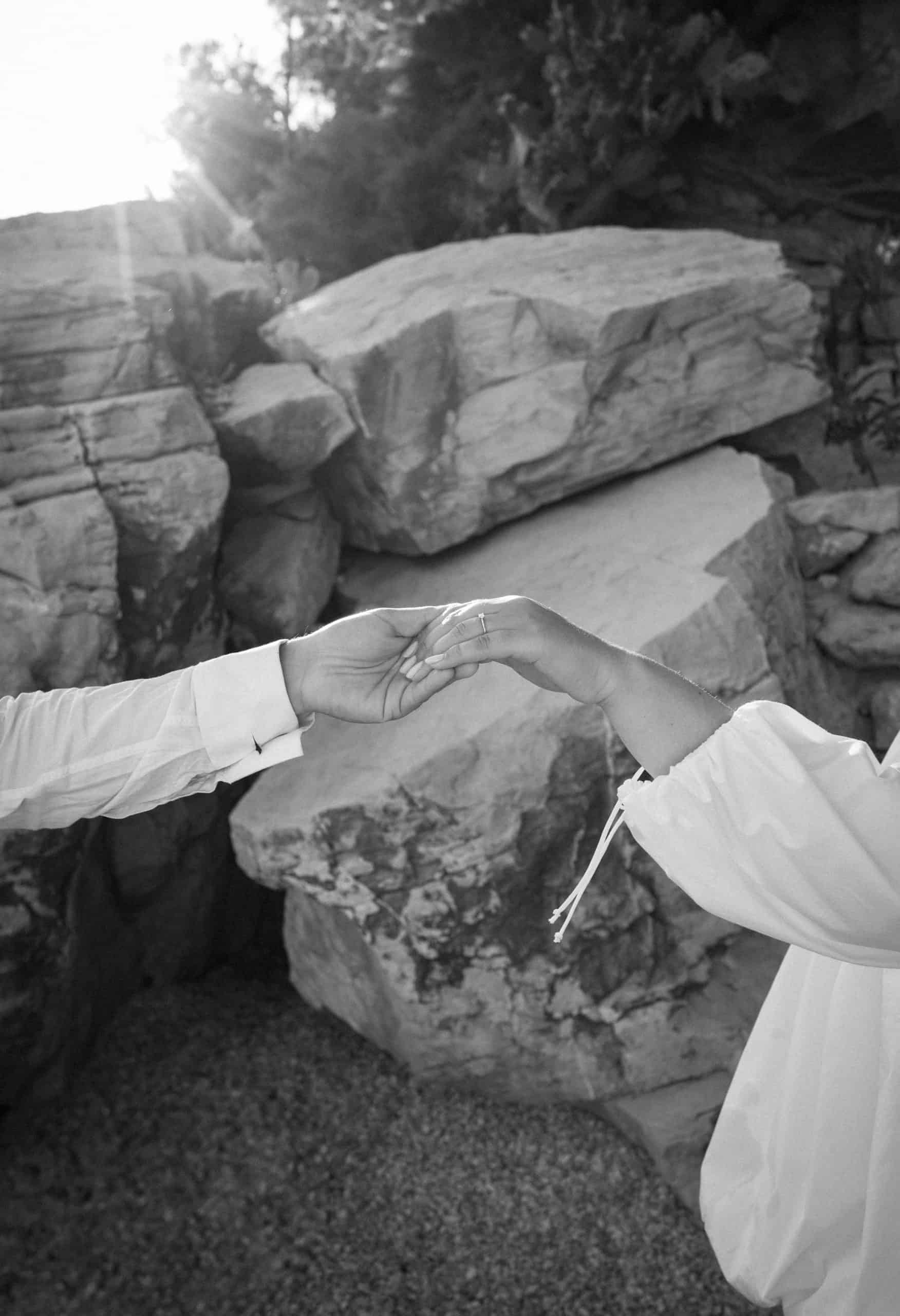 Split, Obojena, crno-bijeli detalj ruku sa zaručničkim prstenom; nježan dodir mladenaca ispred teksture prirodnog kamena.