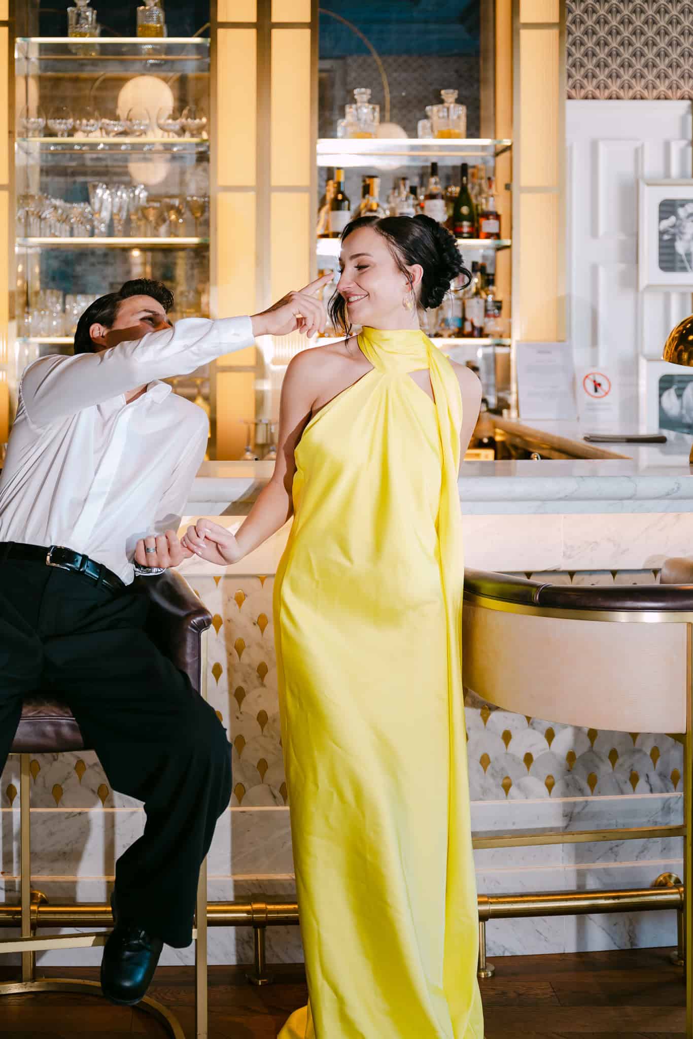 Dubrovnik vjenčani editorijal – spontani i razigrani trenutak na šanku; mladoženja u šali dodiruje nos mladenki u žutoj haljini.