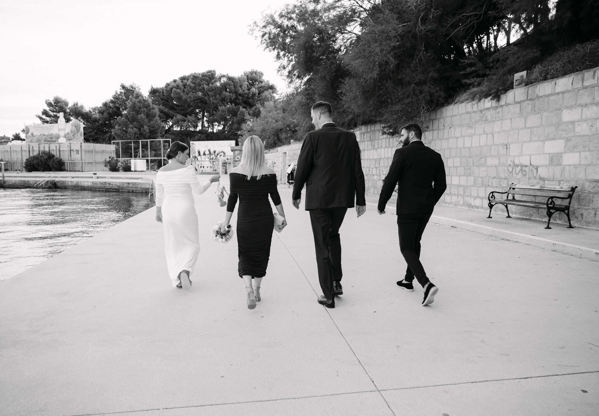 Mladenci i kumovi na vjenčanju u Splitu; elegantna šetnja uz more na Bačvicama, moderna vjenčana fotografija.