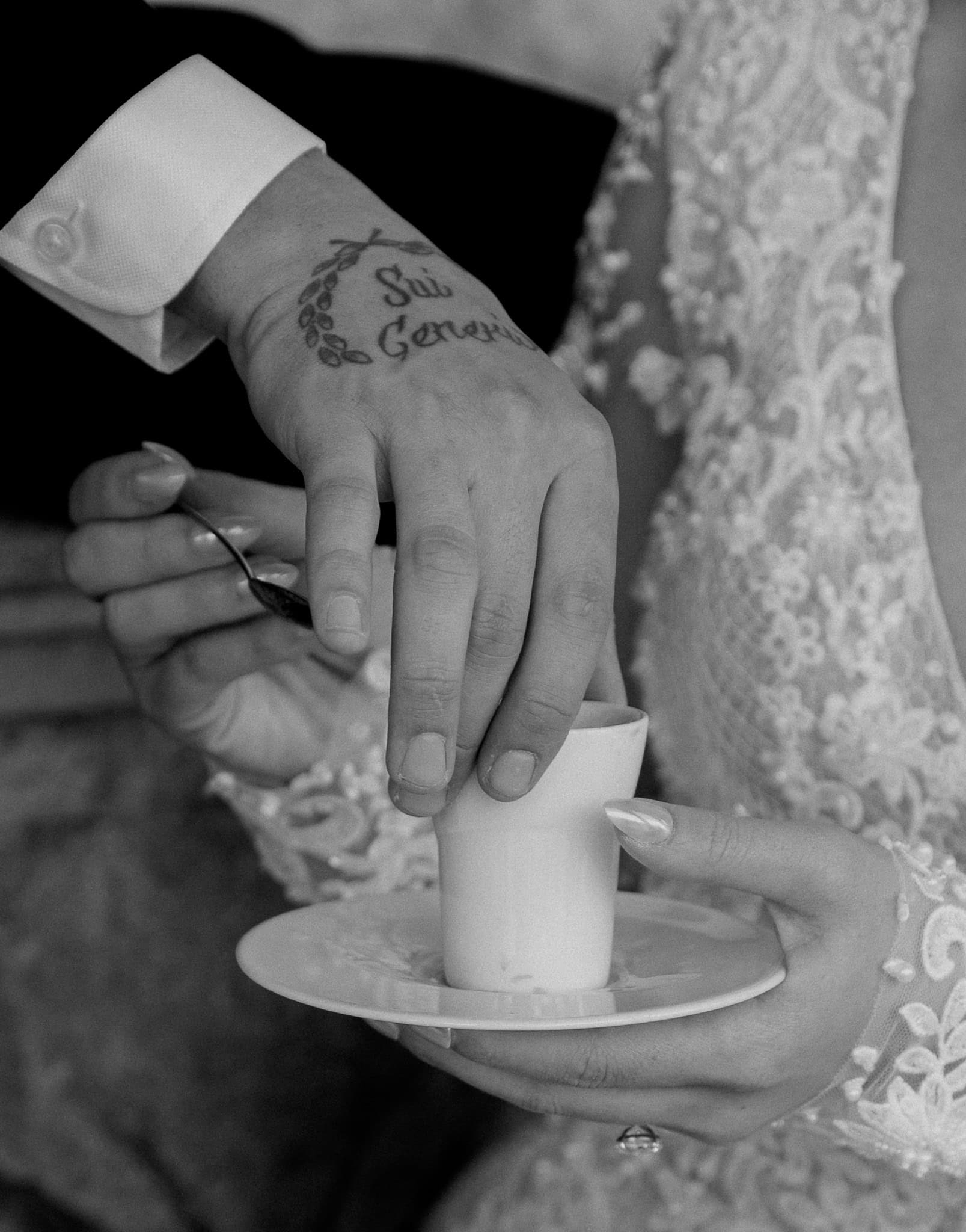 Dubrovnik wedding fotograf – krupni crno-bijeli detalj ruku mladenaca; fokus na zaručnički prsten, šalicu kave i mladoženjinu tetovažu u opuštenom trenutku.