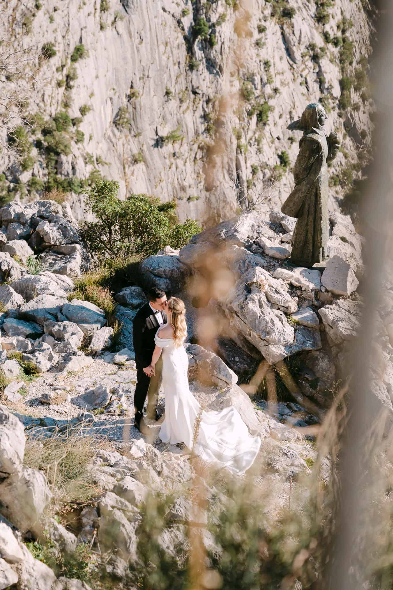 Poljubac mladenaca na stijenama vidikovca iznad Omiša uz prepoznatljivi kip Mile Gojsalić.