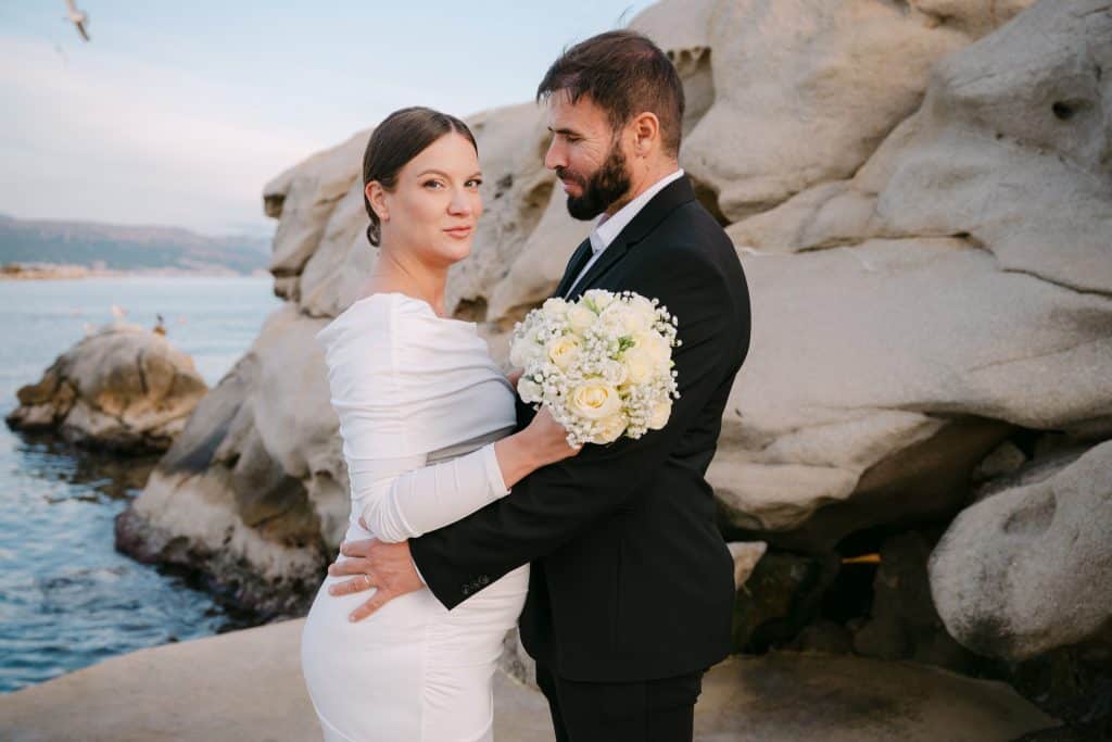 Portret mladenke i mladoženje na stjenovitoj obali grada Splita za vjenčanu fotografiju.