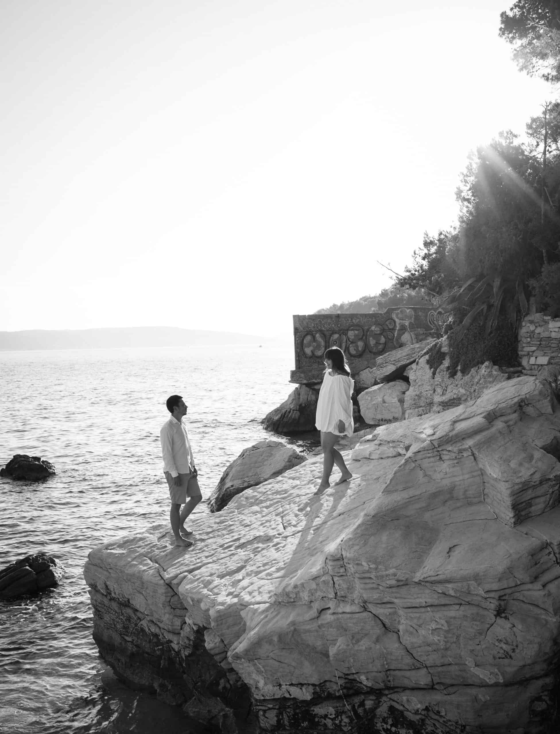 Split, hridi uz more: zaručnički portret na osami splitske obale; par u bijeloj ljetnoj odjeći na stijenama tijekom zaručnikog sessiona.