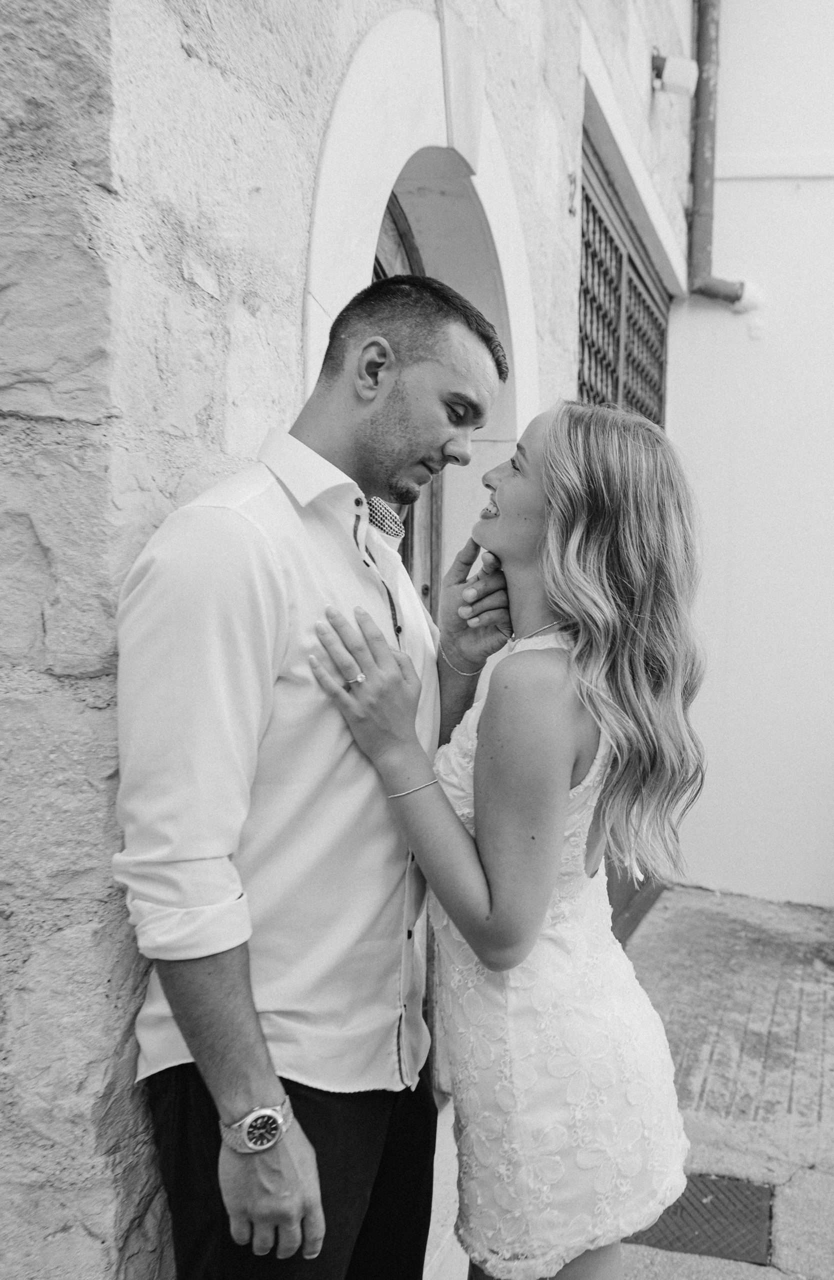 Par u ljubavnom zagrljaju na ulici, filmska fotografija u crno-bijeloj boji.