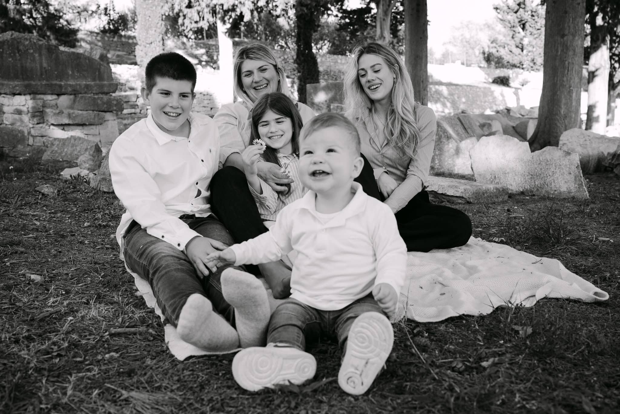 Obiteljski portret na otvorenom s djecom i roditeljima u parku.