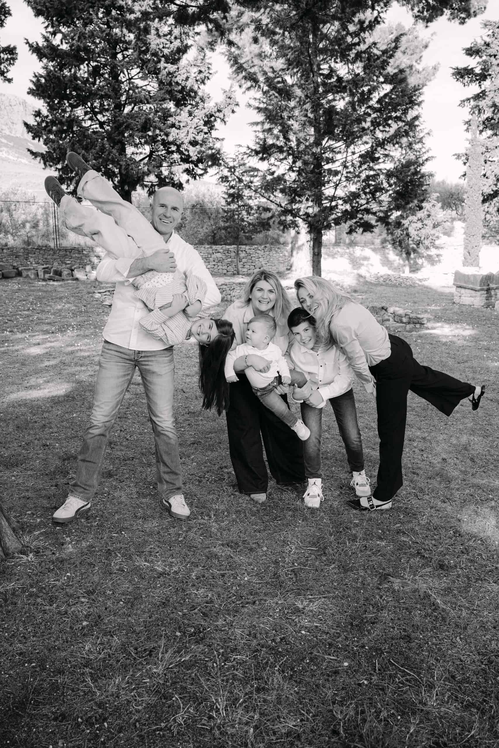 Obiteljski portret na otvorenom u parku s djecom i roditeljima, crno-bijeli.