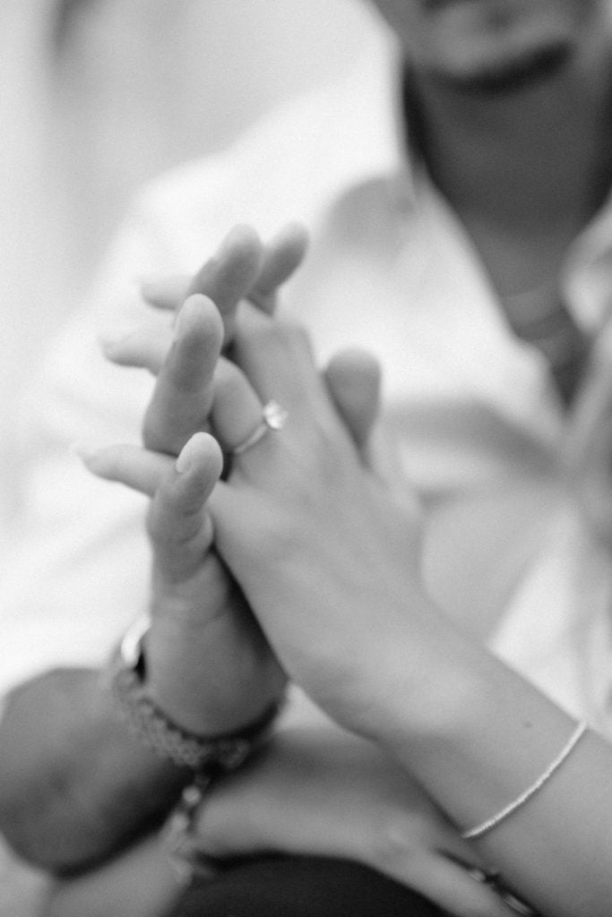 Ljubavni dodir ruku u crno-bijeloj fotografiji, simbol intimnosti i povezanosti.