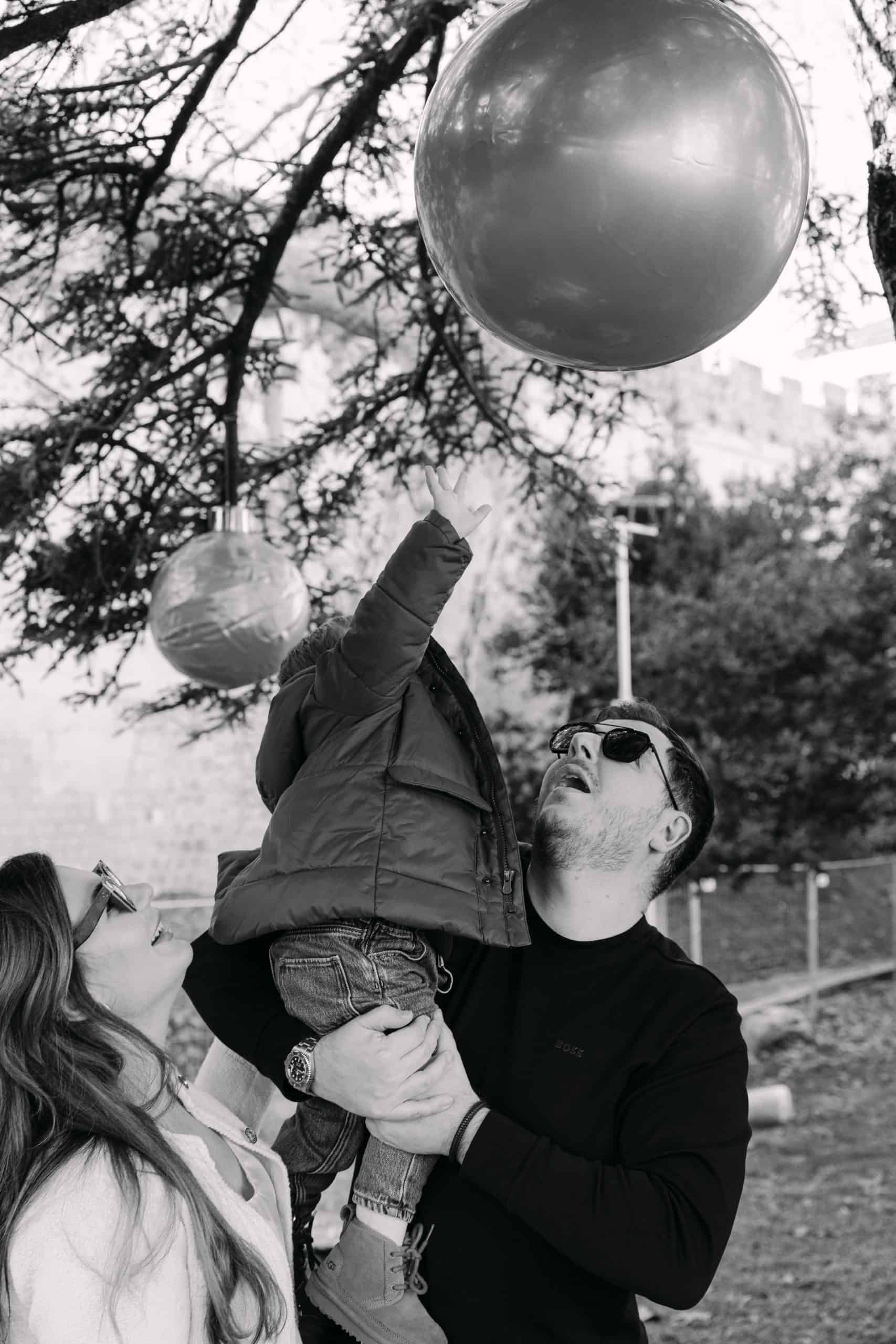 Obitelj se igra s balonima na otvorenom u parku.