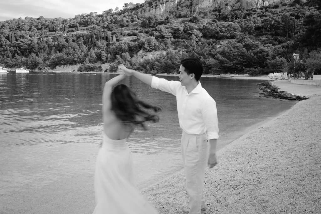 Spontani ples i sreća: umjetnička crno-bijela fotografija tijekom snimanja na moru.