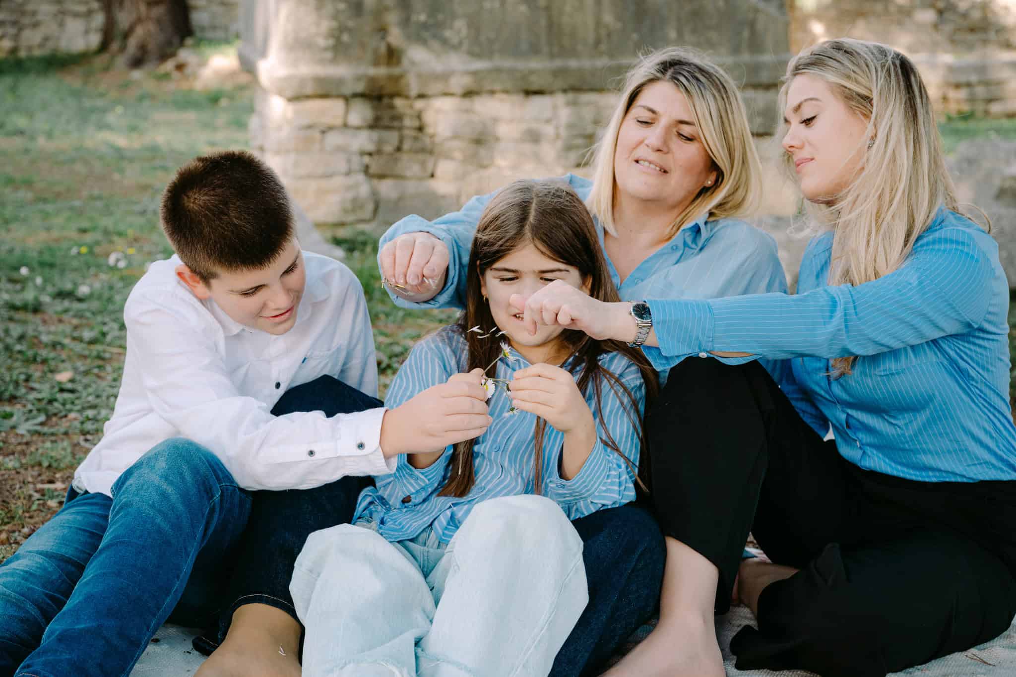 Obiteljski portret na otvorenom s djecom i majkom dok se igraju.