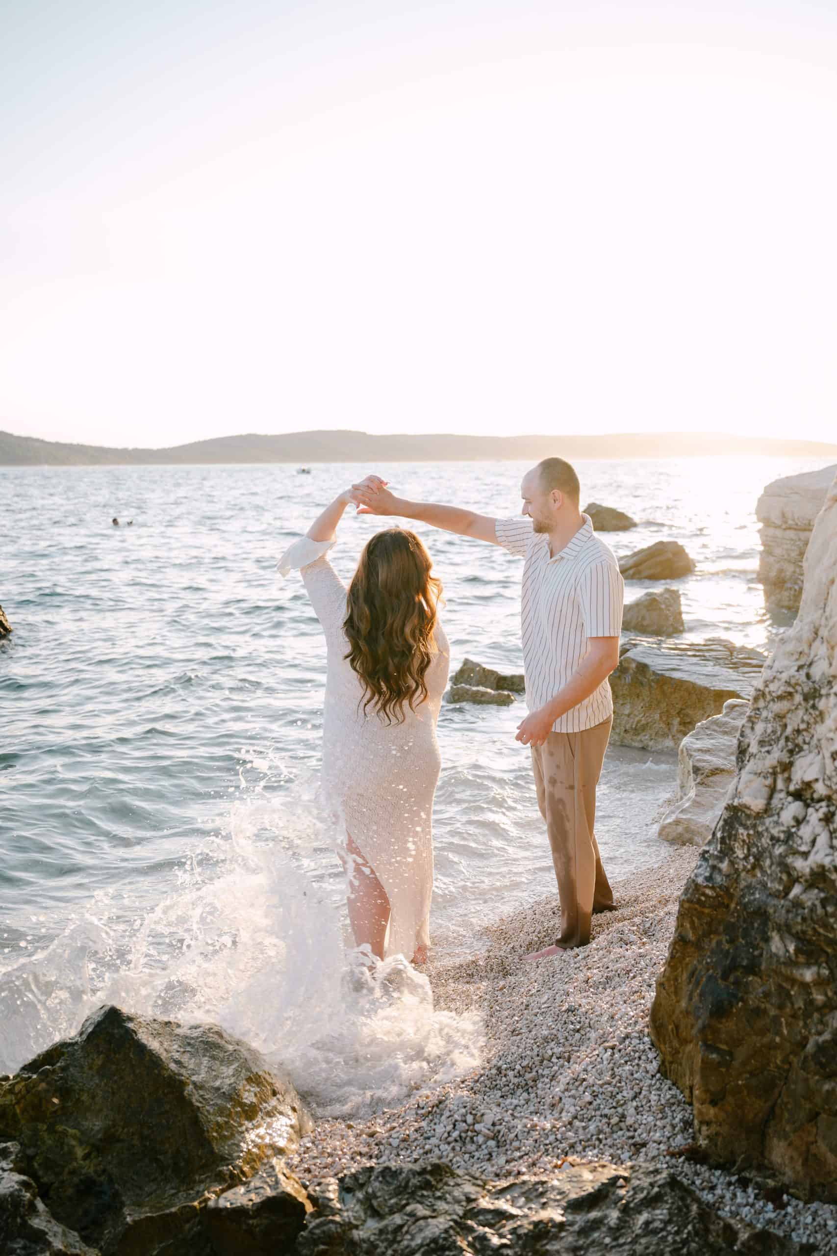 Par na plaži, romantična fotografija uz zalazak sunca.