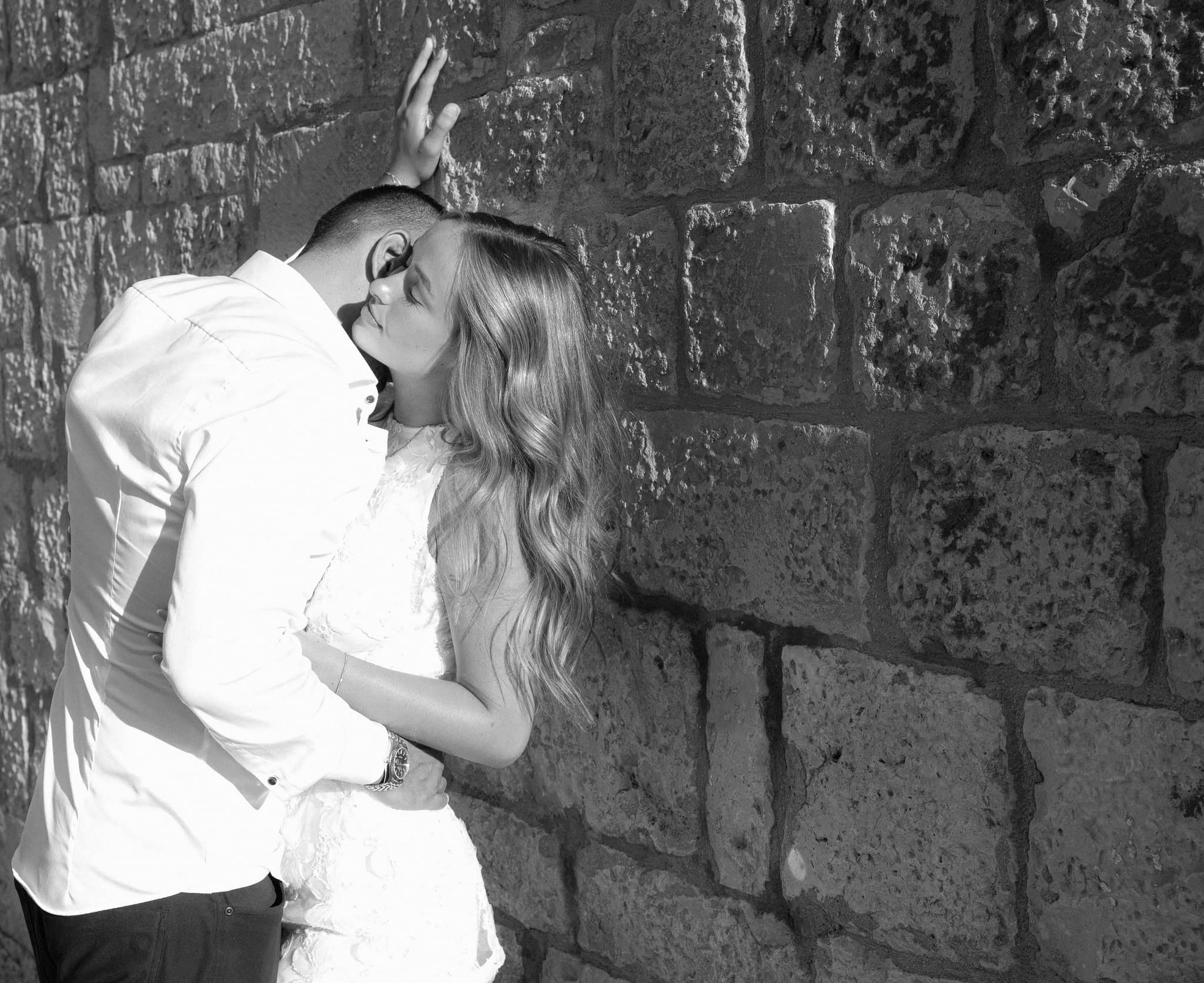 Zaručnički par dijeli zagrljaj na otvorenom.