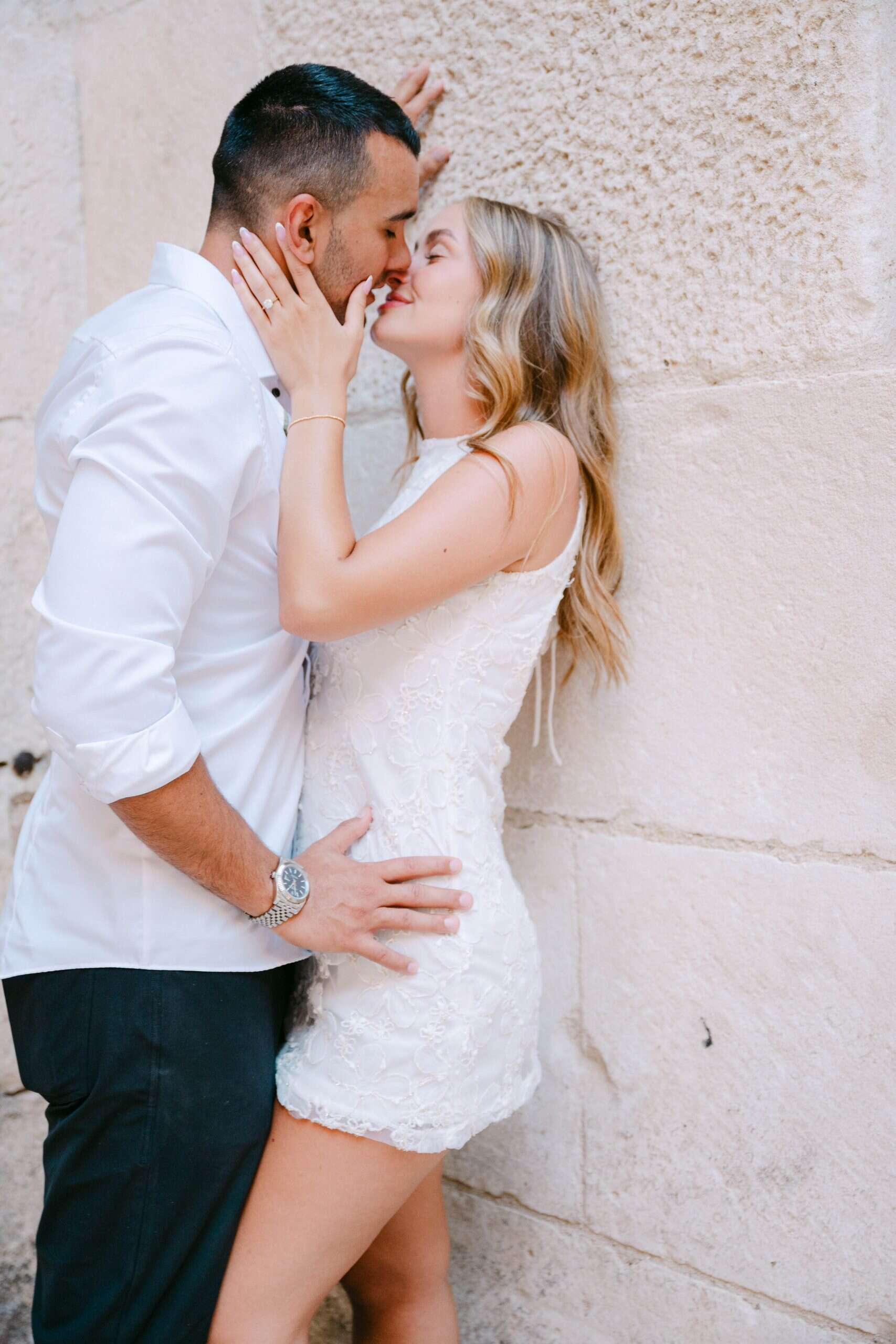 Zaručeni par se ljubi na ulici, romantični trenutak u centru grada.