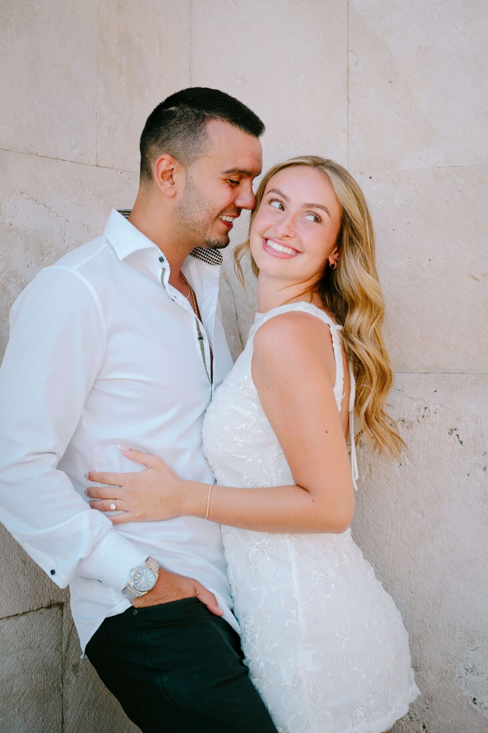 Slika sretnog para koji se grli na otvorenom, smiješe se i muškarac gleda u ženu.