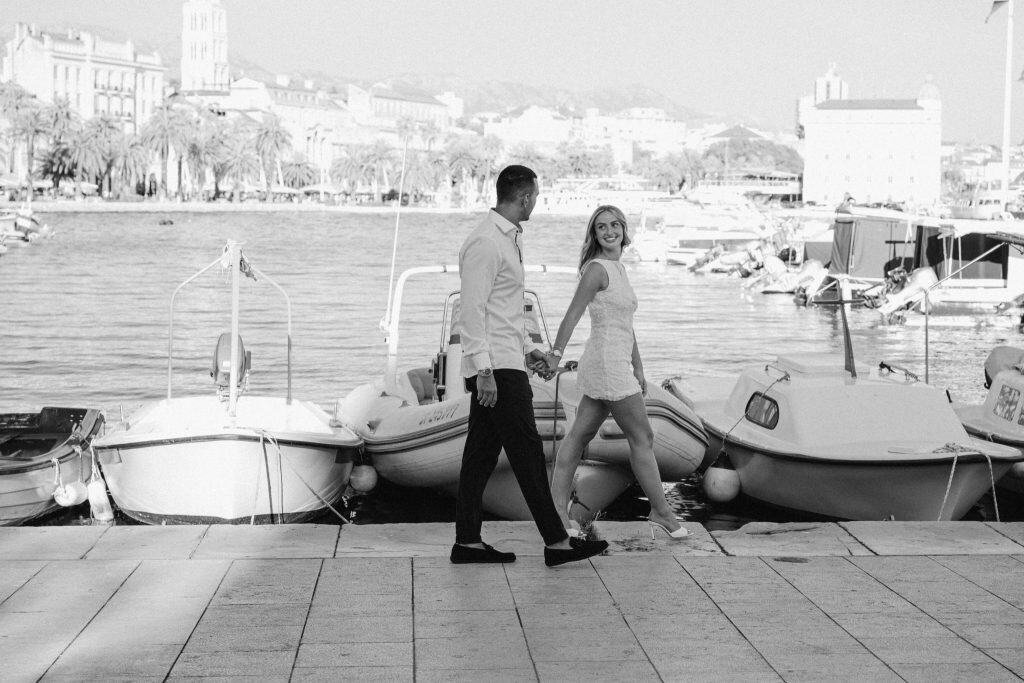 Ljubavni par šeta uz obalu, uživajući u romantičnoj atmosferi.