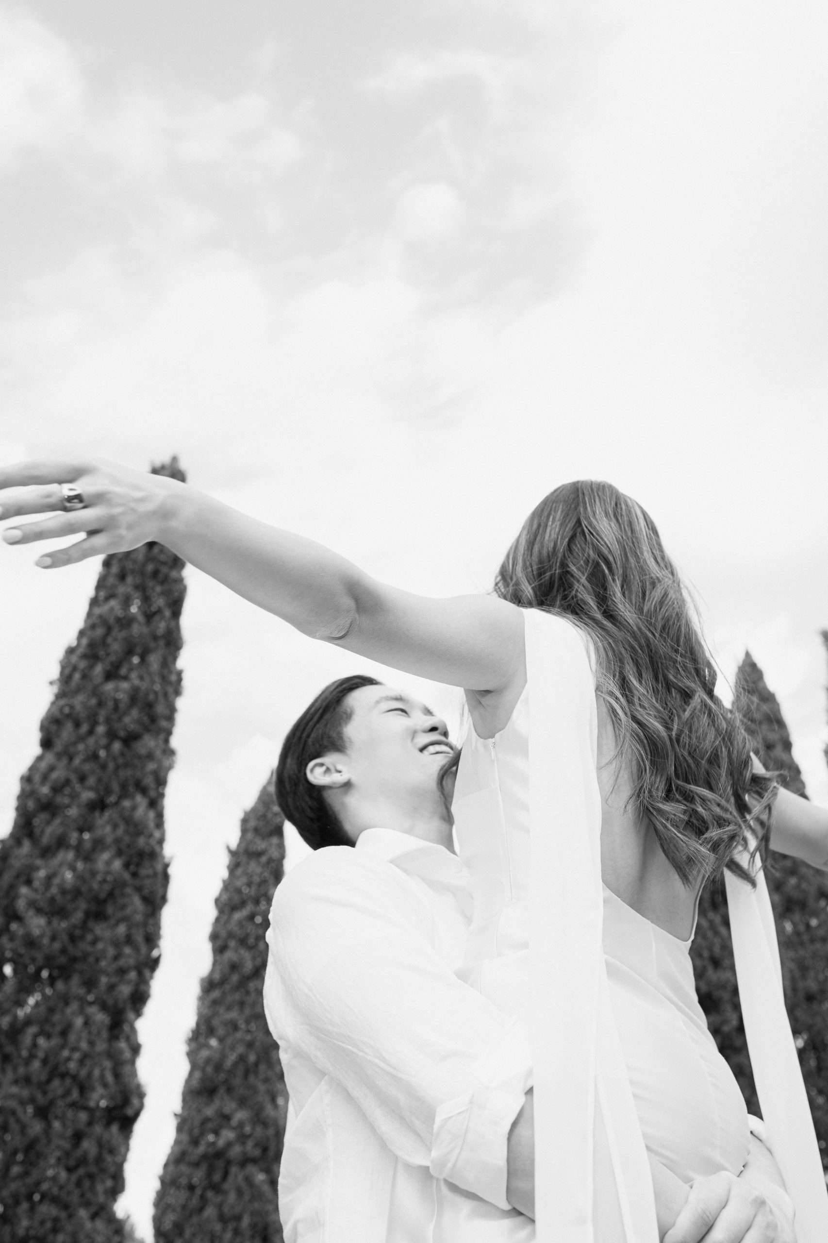 Sretan par se vrti s raširenim rukama, uživajući u sunčanom danu.