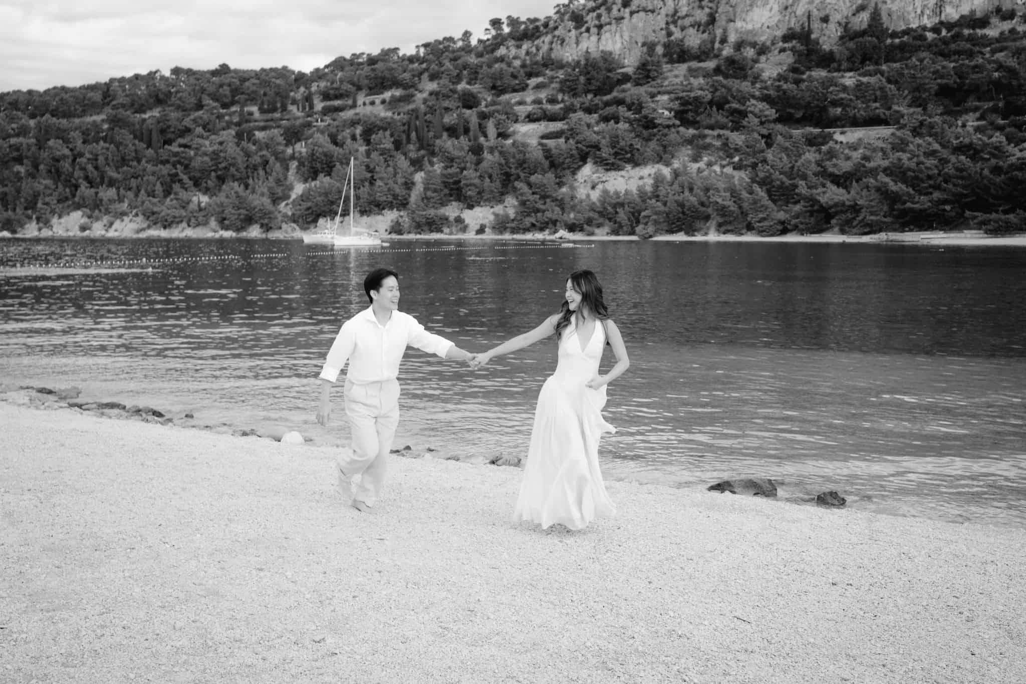 Par se veselo smije i trči na plaži uz more u spontanom trenutku tijekom after wedding sessiona na splitskoj obali.