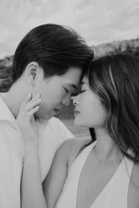 Crno-bijela fotografija vjenčanog para s dodirnutim čelima.