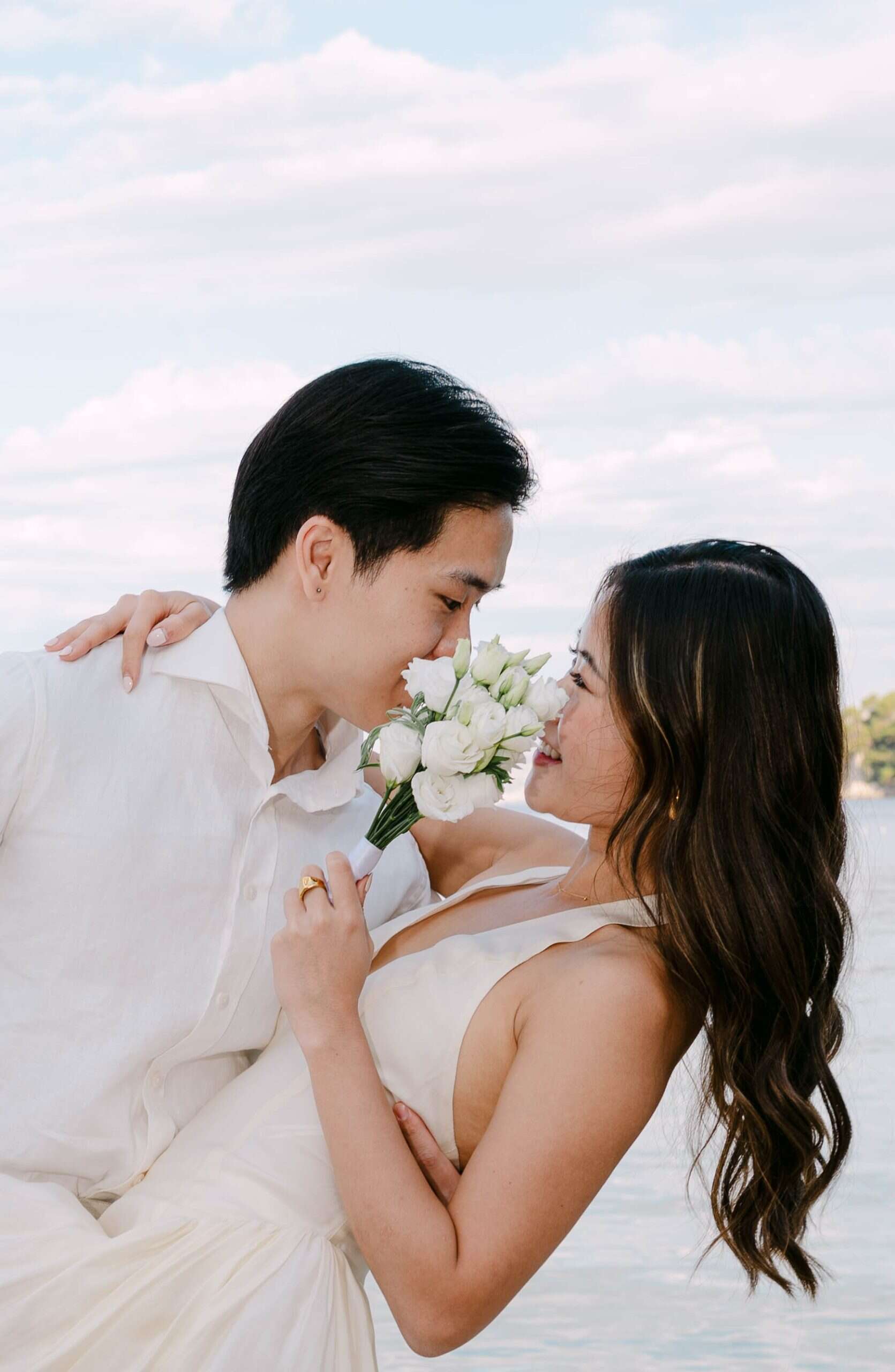 Mladenci Stephanie i Bank u intimnom trenutku s bijelim vjenčanim buketom, fotografirano u Splitu.