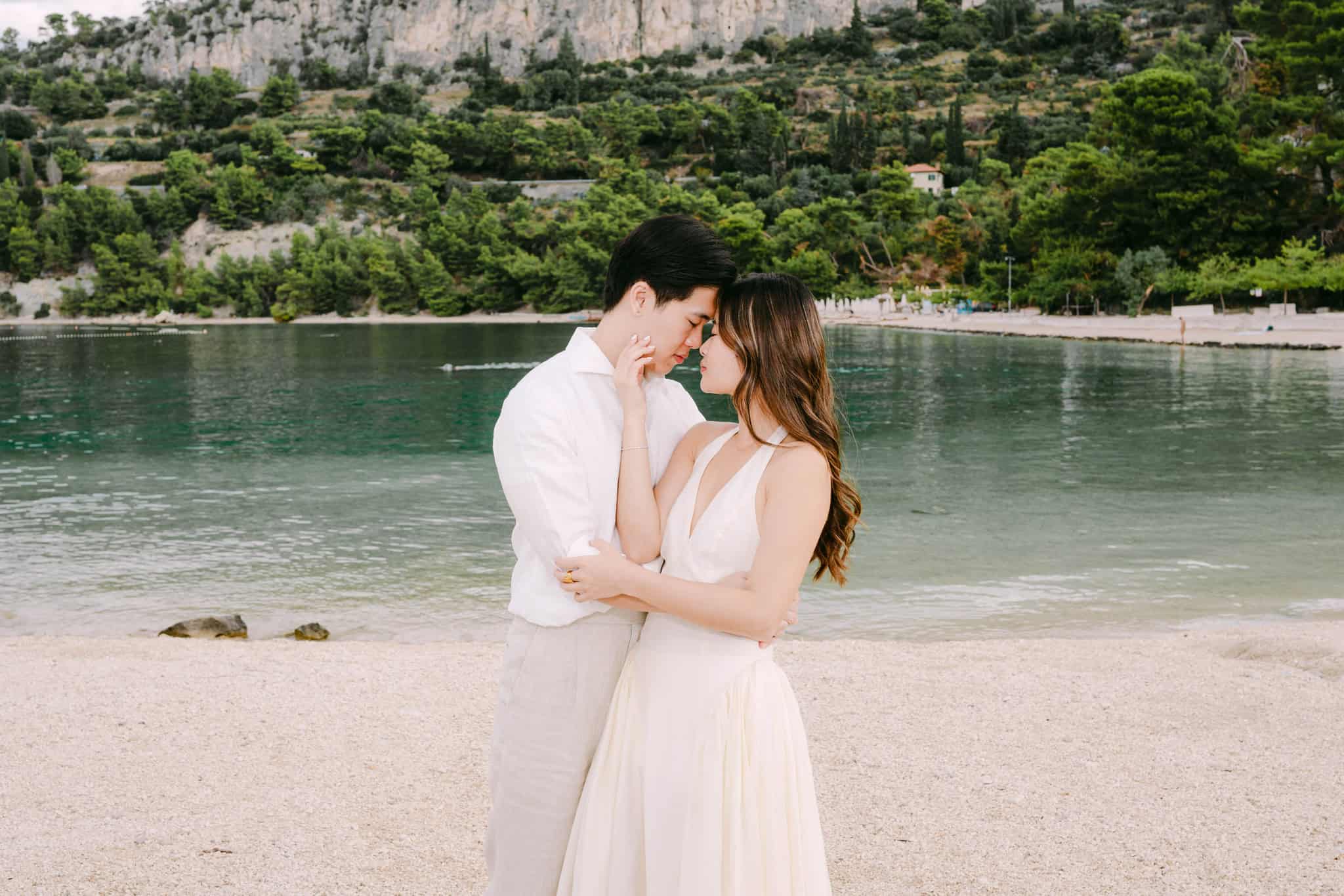 Zaljubljeni par u zagrljaju na plaži uz more.