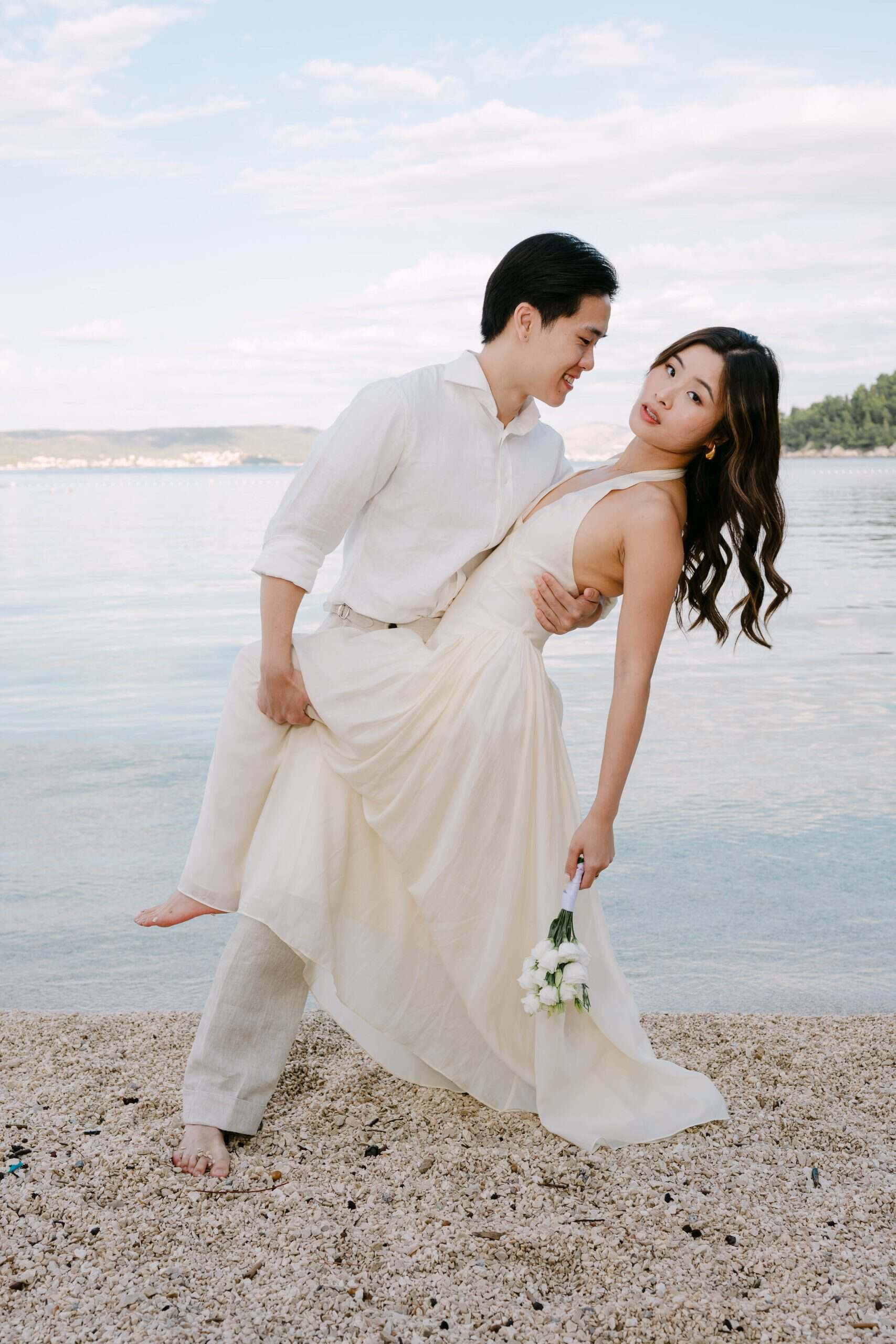 Vjenčani par ispred plaže Kajšuni s morem i zelenilom u pozadini.