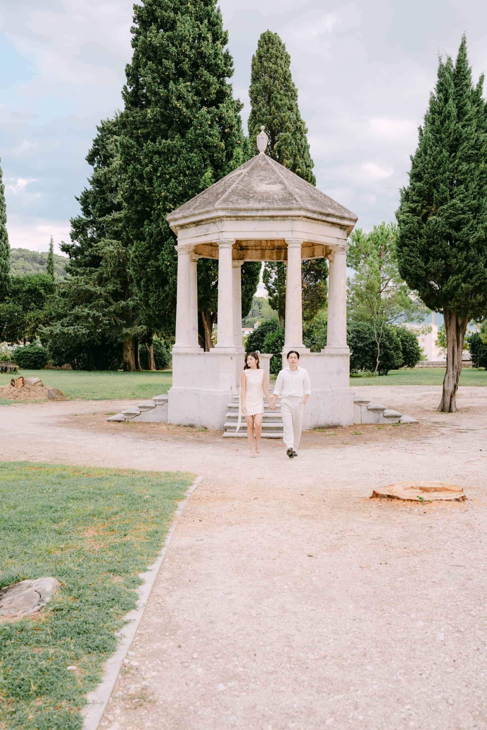 Elegantno after wedding snimanje u Splitu: par se drži za ruke ispred kamene sjenice na Sustipanu.