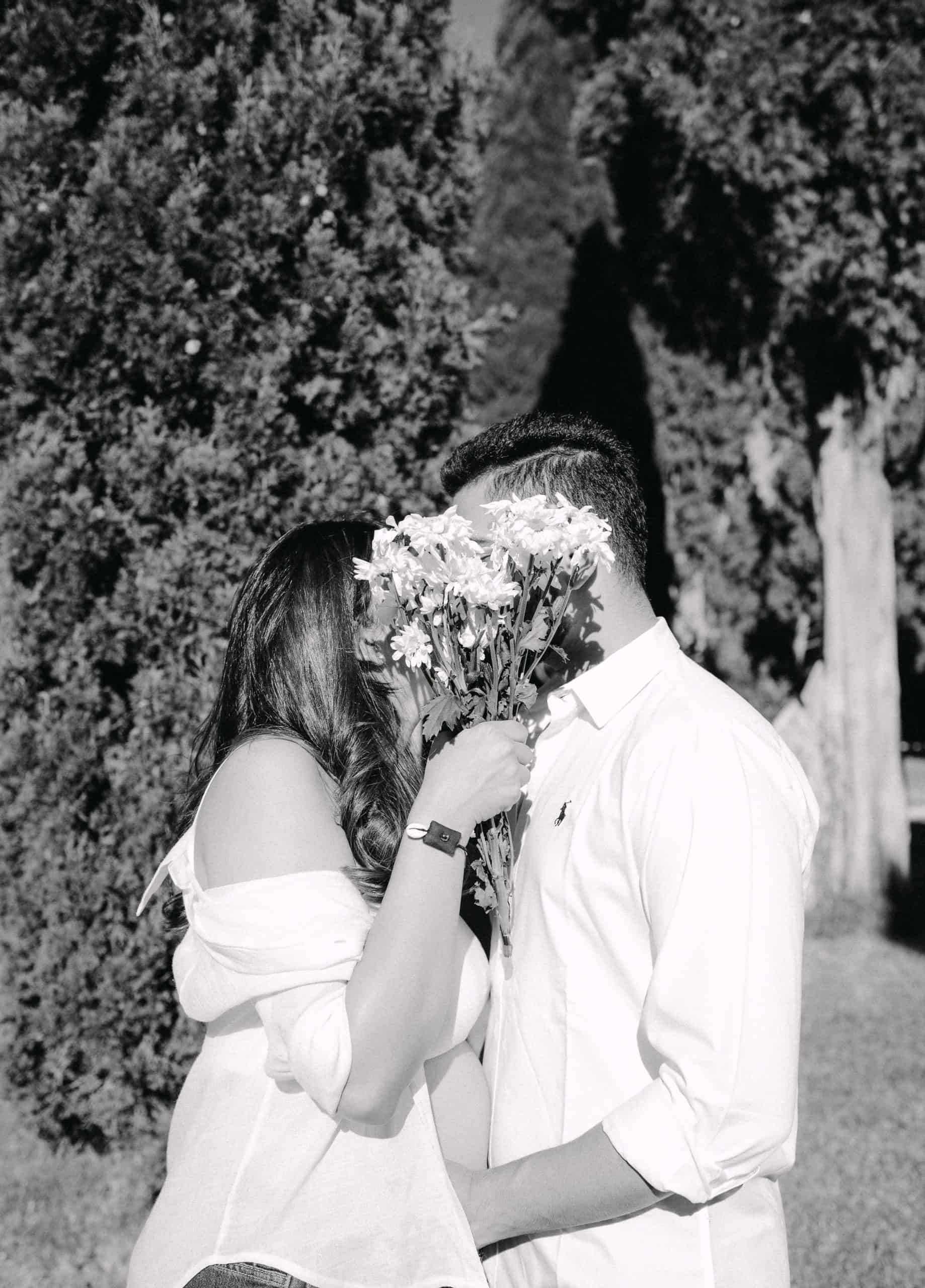 Par drži buket cvijeća, romantični trenutak u prirodi.