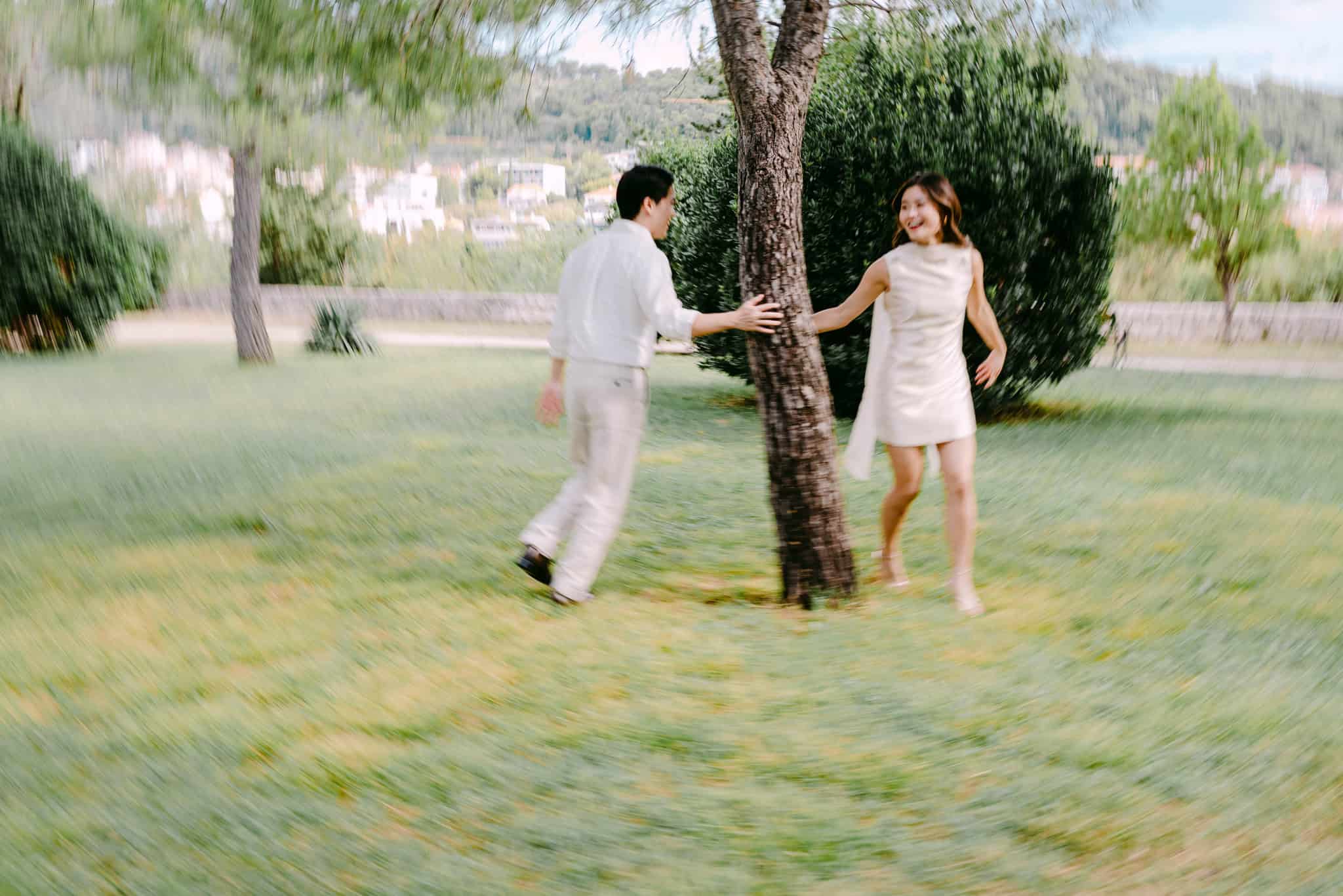 Par se igra lovice i drže se rukama oko drveta u parku Sustipan u gradu Splitu.