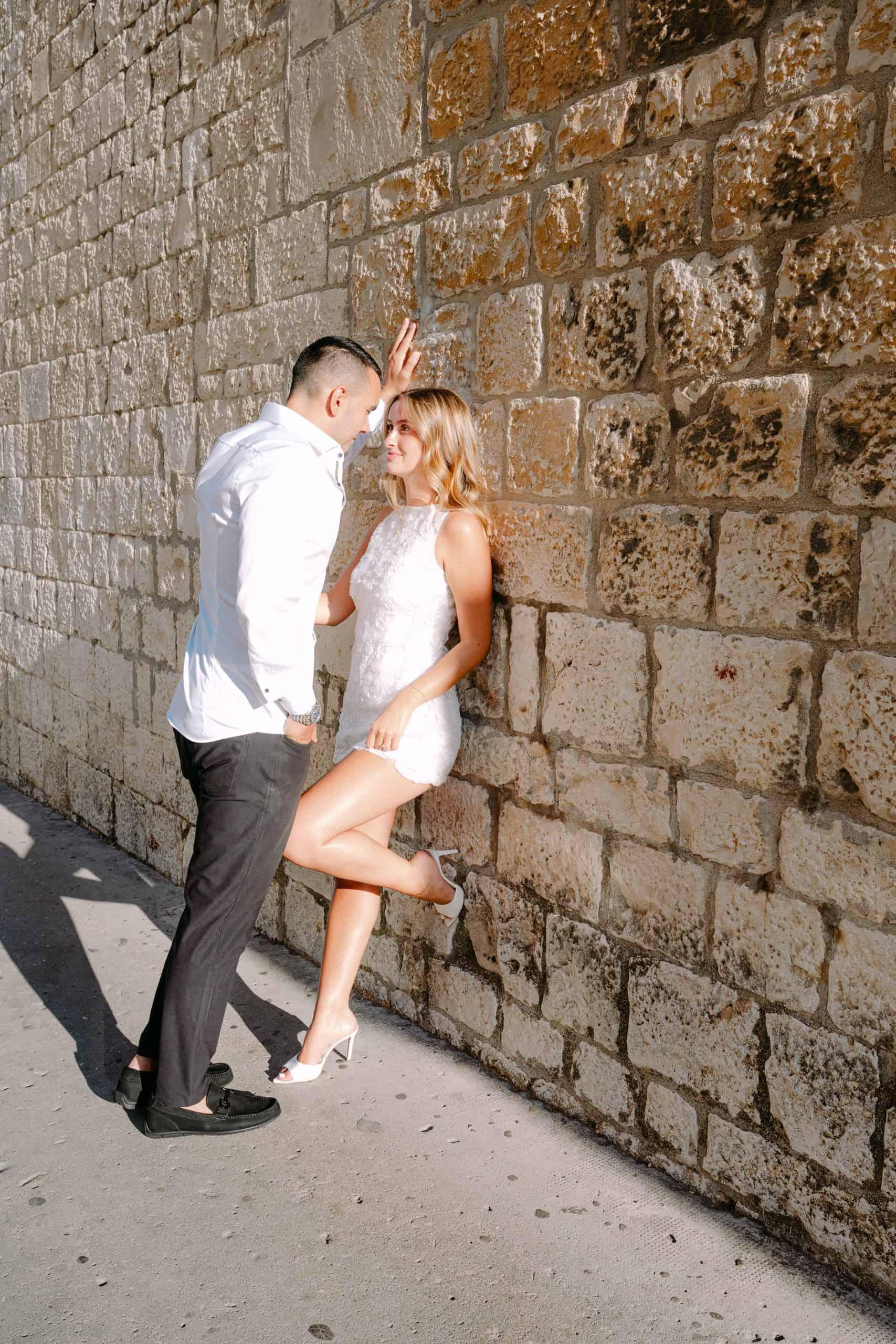 Zaručnici Cristina i Ratko u krupnom planu, razmjenjuju emotivne poglede ispred kamenog zida u Splitu.